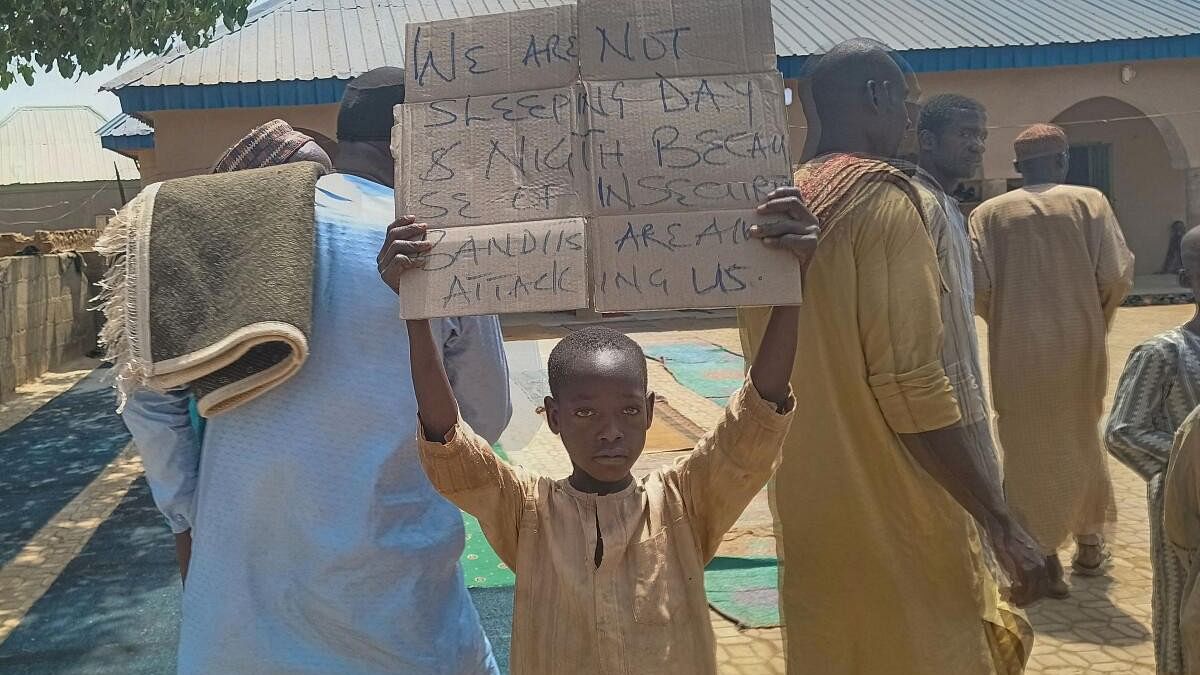<div class="paragraphs"><p>A boy holds a sign to protest against, what a teacher, local councilor and parents said, the kidnapping of hundreds school pupils by gunmen after the Friday prayer in Kaduna, Nigeria.</p></div>