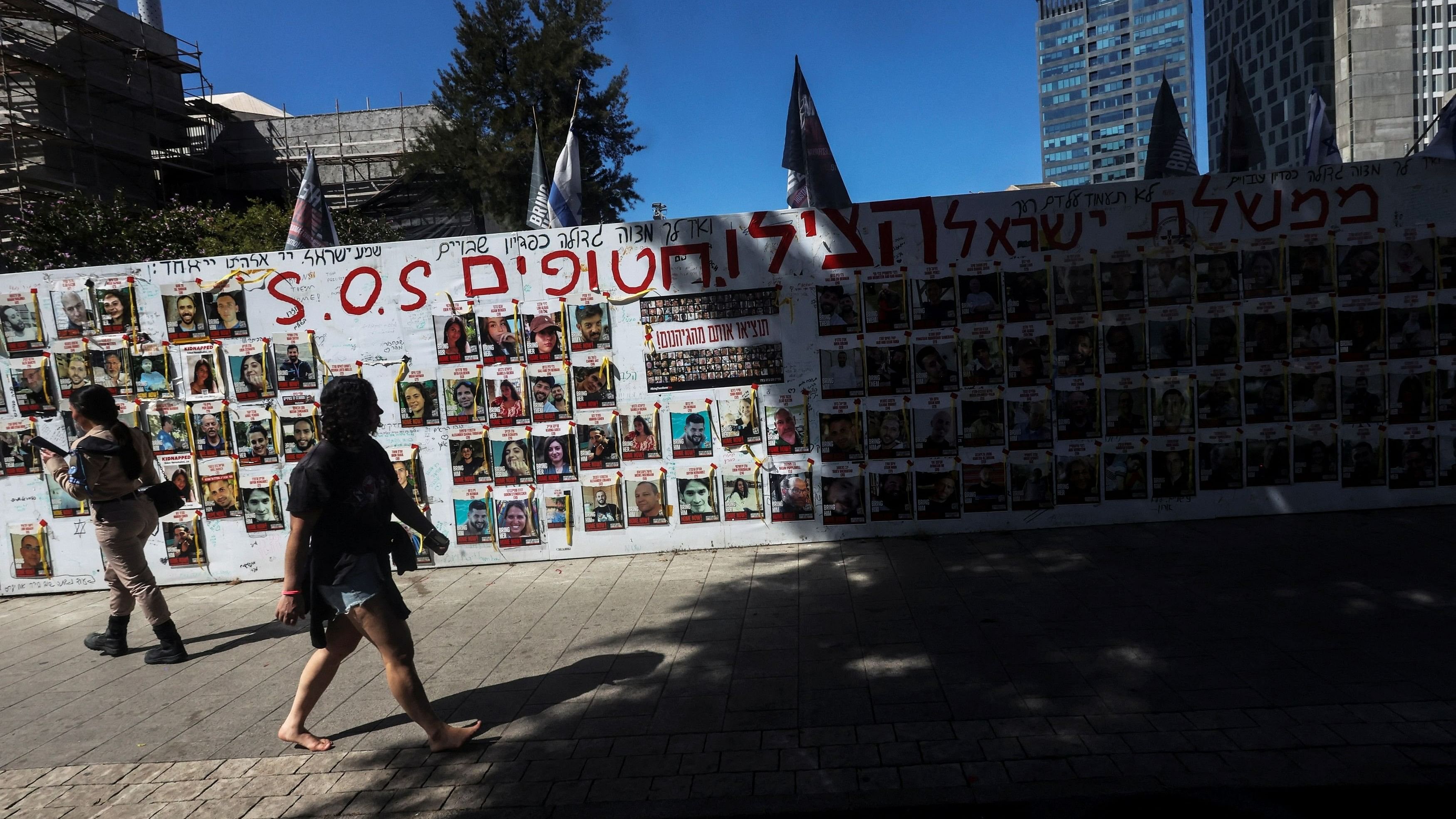 <div class="paragraphs"><p>People walk past a wall of messages and posters of Israeli hostages held in the Gaza Strip, amid the ongoing conflict between Israel and the Palestinian Islamist group Hamas, in a public square in Tel Aviv, Israel, March 12, 2024. </p></div>