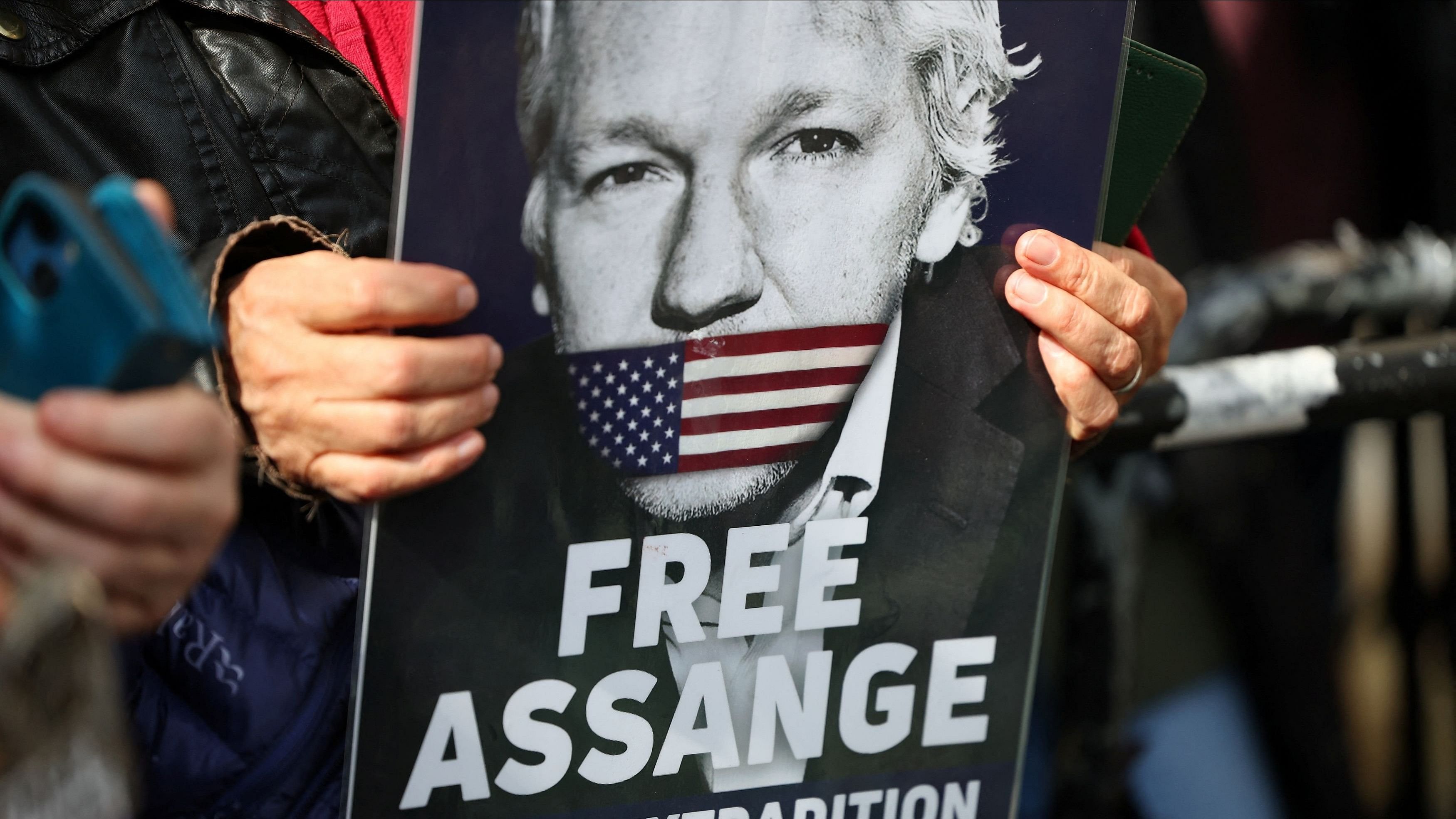 <div class="paragraphs"><p>A supporter of WikiLeaks founder Julian Assange holds a sign.</p></div>