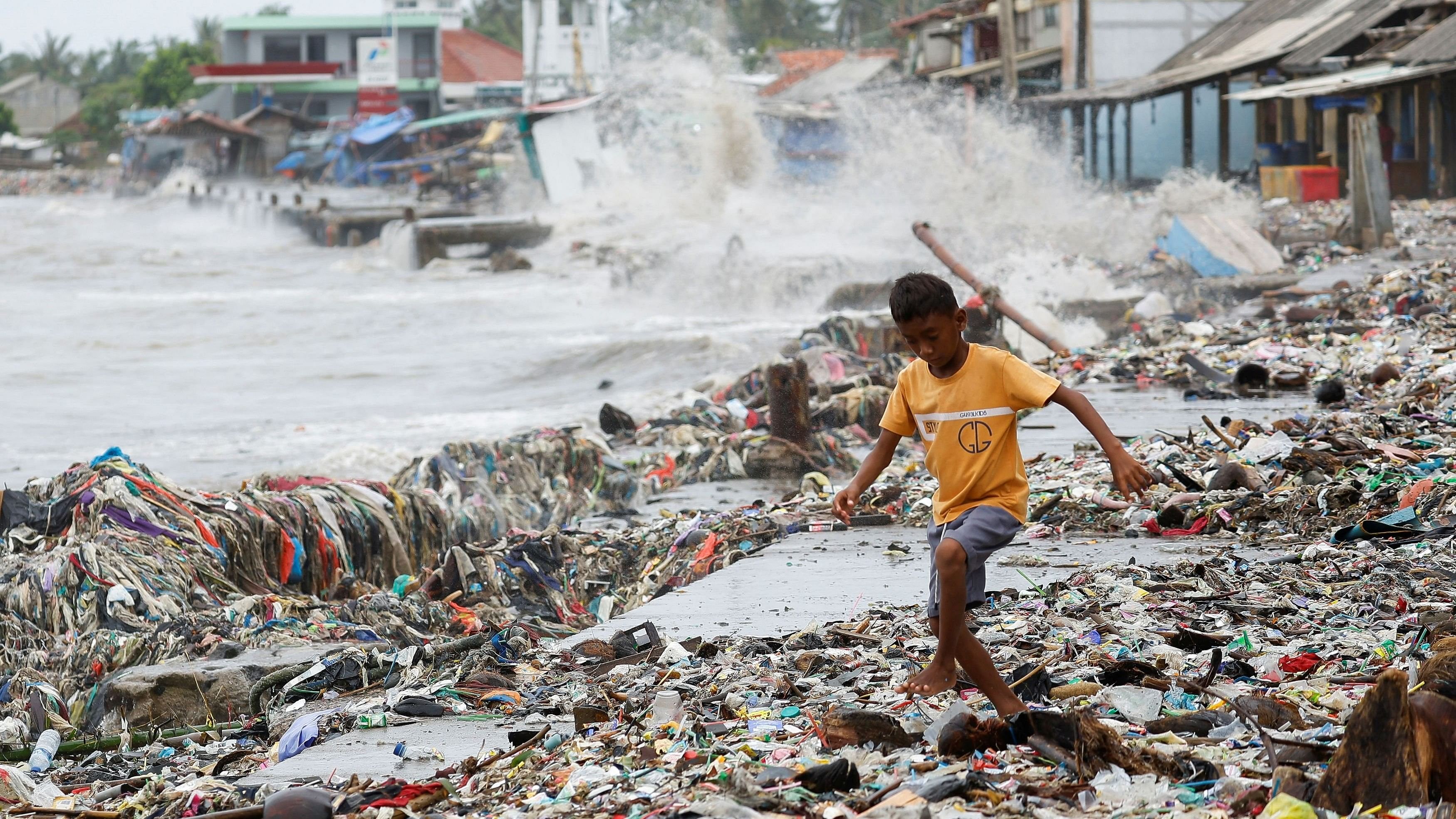 <div class="paragraphs"><p>A boy runs through piles of trash, most of which is plastics and domestic waste, on a beach in Teluk fishing village.</p></div>