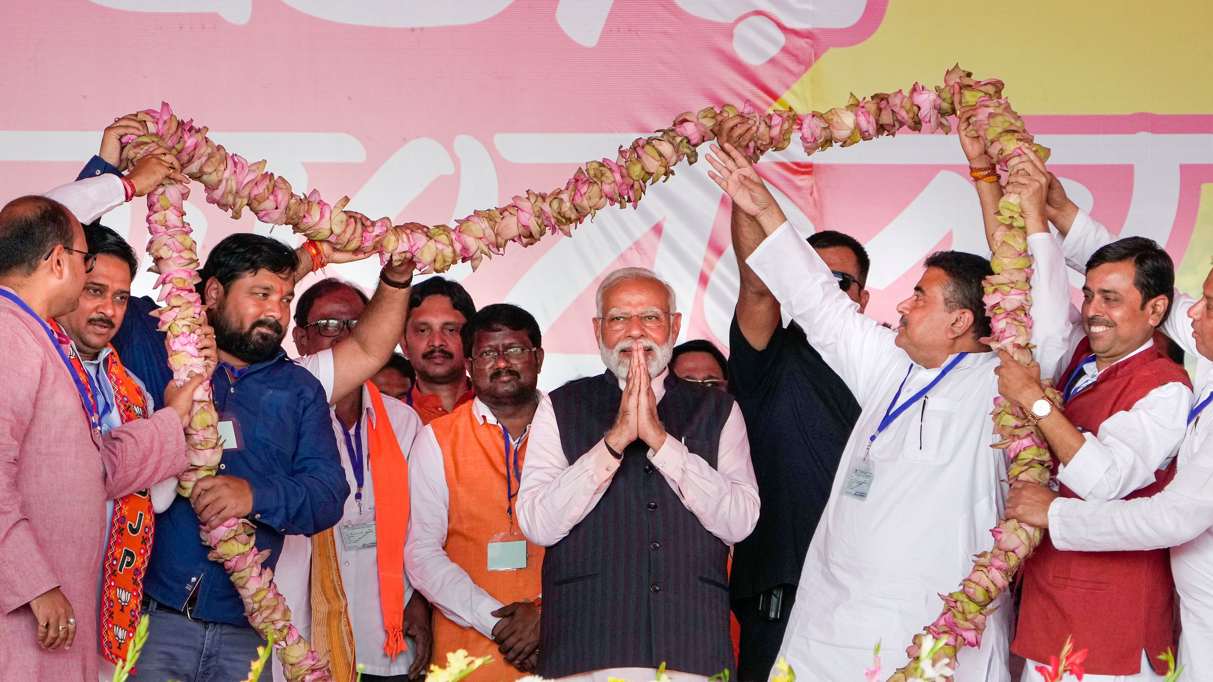 <div class="paragraphs"><p>Prime Minister Narendra Modi being garlanded by Leader of the Opposition in West Bengal Assembly Suvendu Adhikari and other BJP leaders during a rally at Arambagh, in Hooghly district, Friday, March 1, 2024.</p></div>