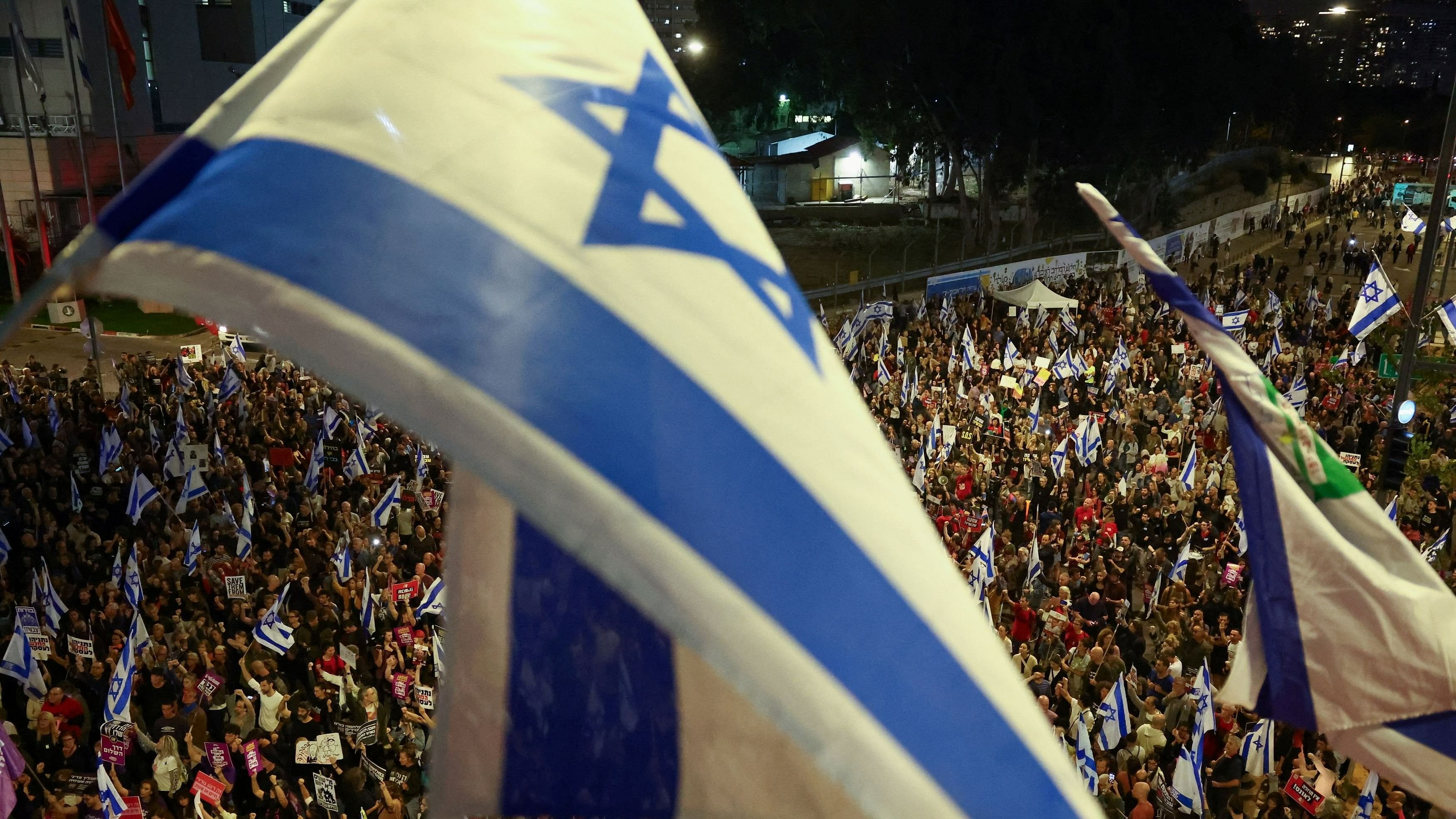 <div class="paragraphs"><p>People hold Israeli flags as they attend a protest against Israeli Prime Minister Benjamin Netanyahu's government and to call for the release of hostages kidnapped in the deadly October 7 attack on Israel by the Palestinian Islamist group Hamas from Gaza, in Tel Aviv, Israel, April 13, 2024. </p></div>