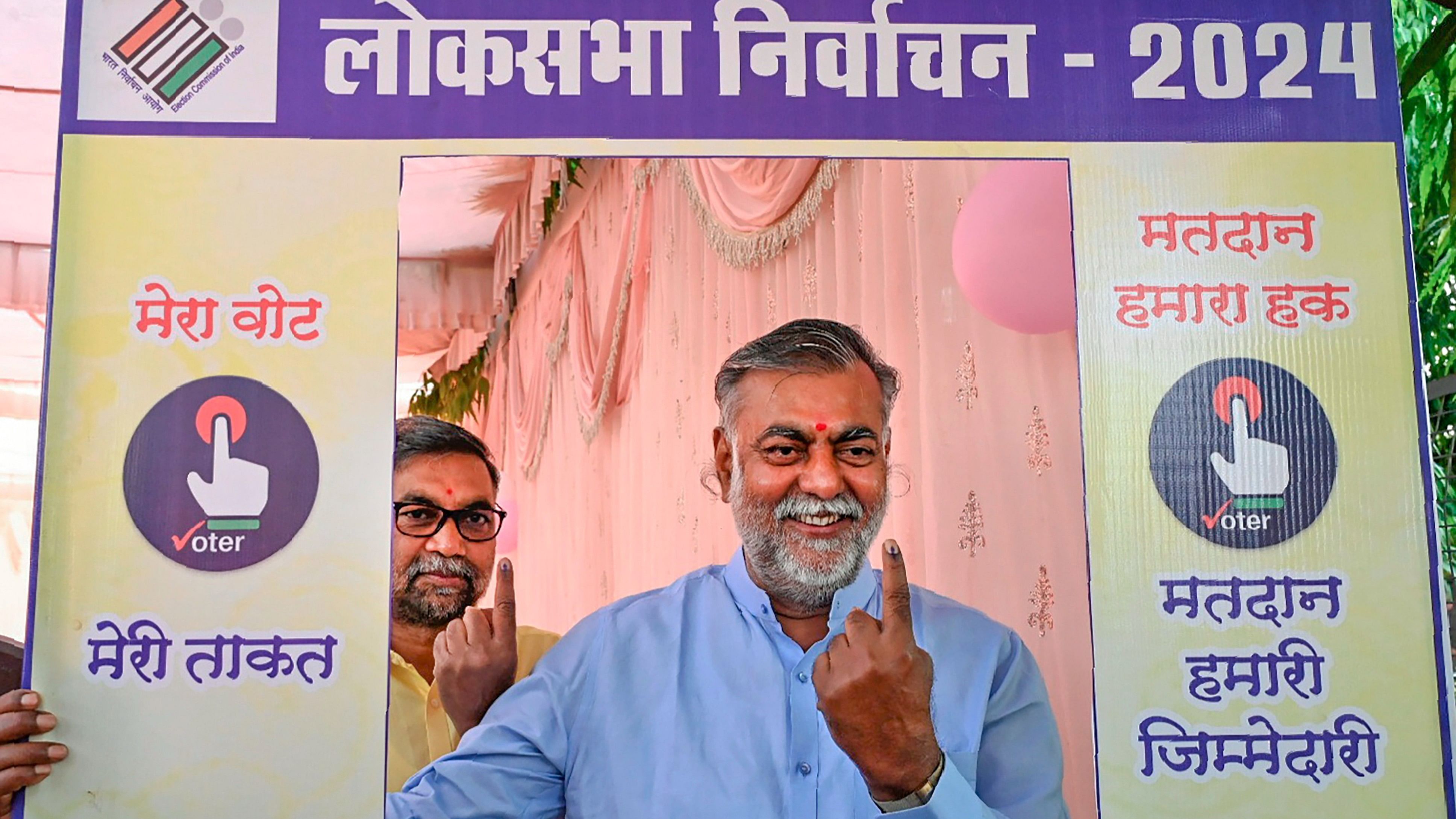 <div class="paragraphs"><p>Madhya Pradesh minister and BJP leader Prahlad Patel shows his inked finger at a selfie stand after casting his vote for the second phase of Lok Sabha elections, in Narsinghpur, on Friday.</p></div>