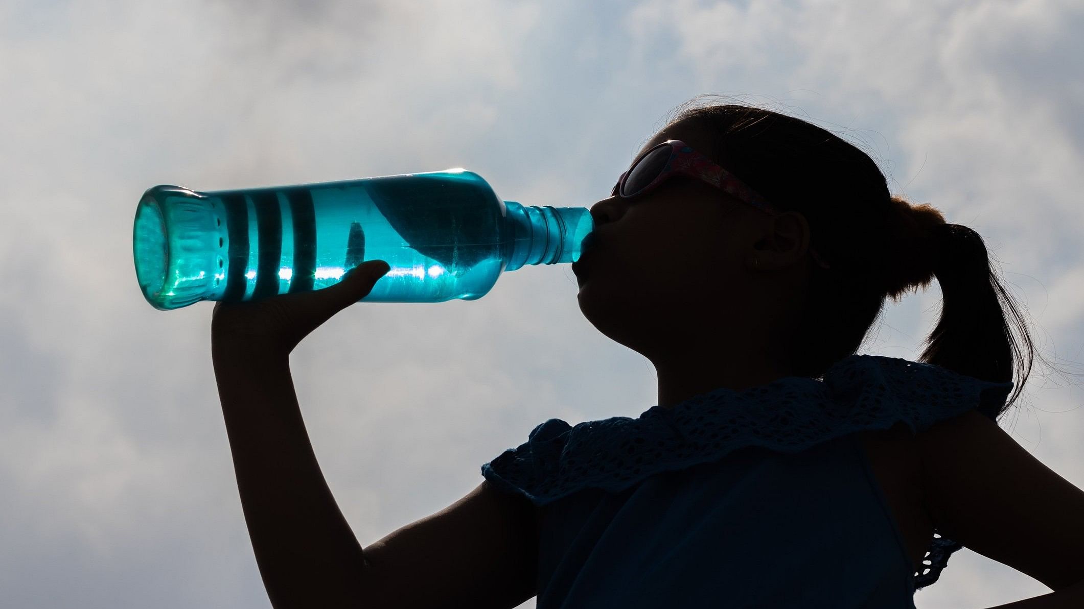 <div class="paragraphs"><p> Representative image showing a girl outlined against the sky drinking water out of a bottle.</p></div>