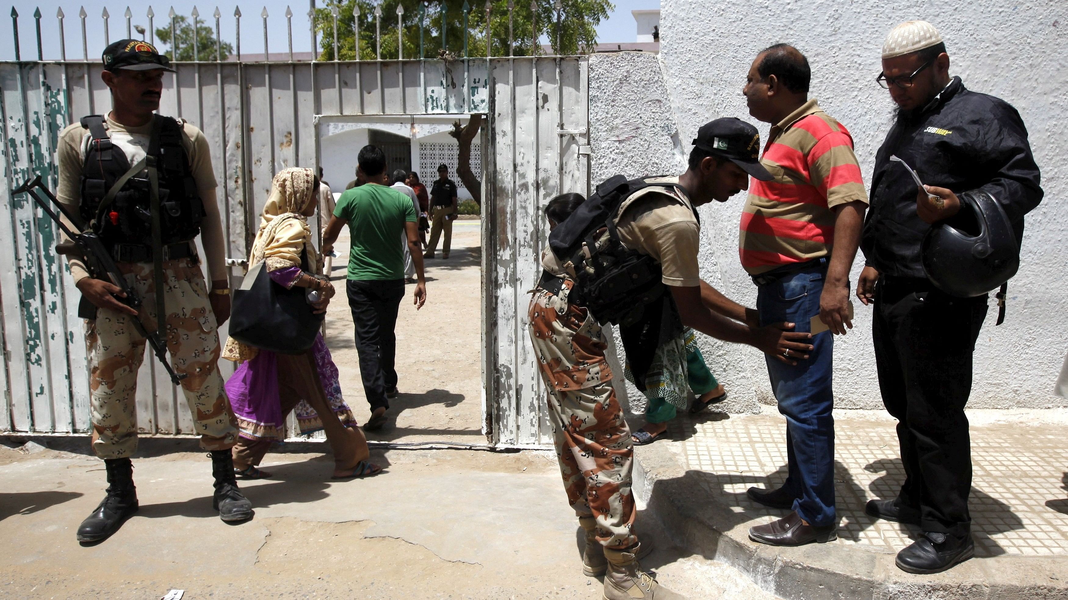 <div class="paragraphs"><p>Representative image of Pakistan paramilitary personnel search voters outside a polling station during the by-election.</p></div>