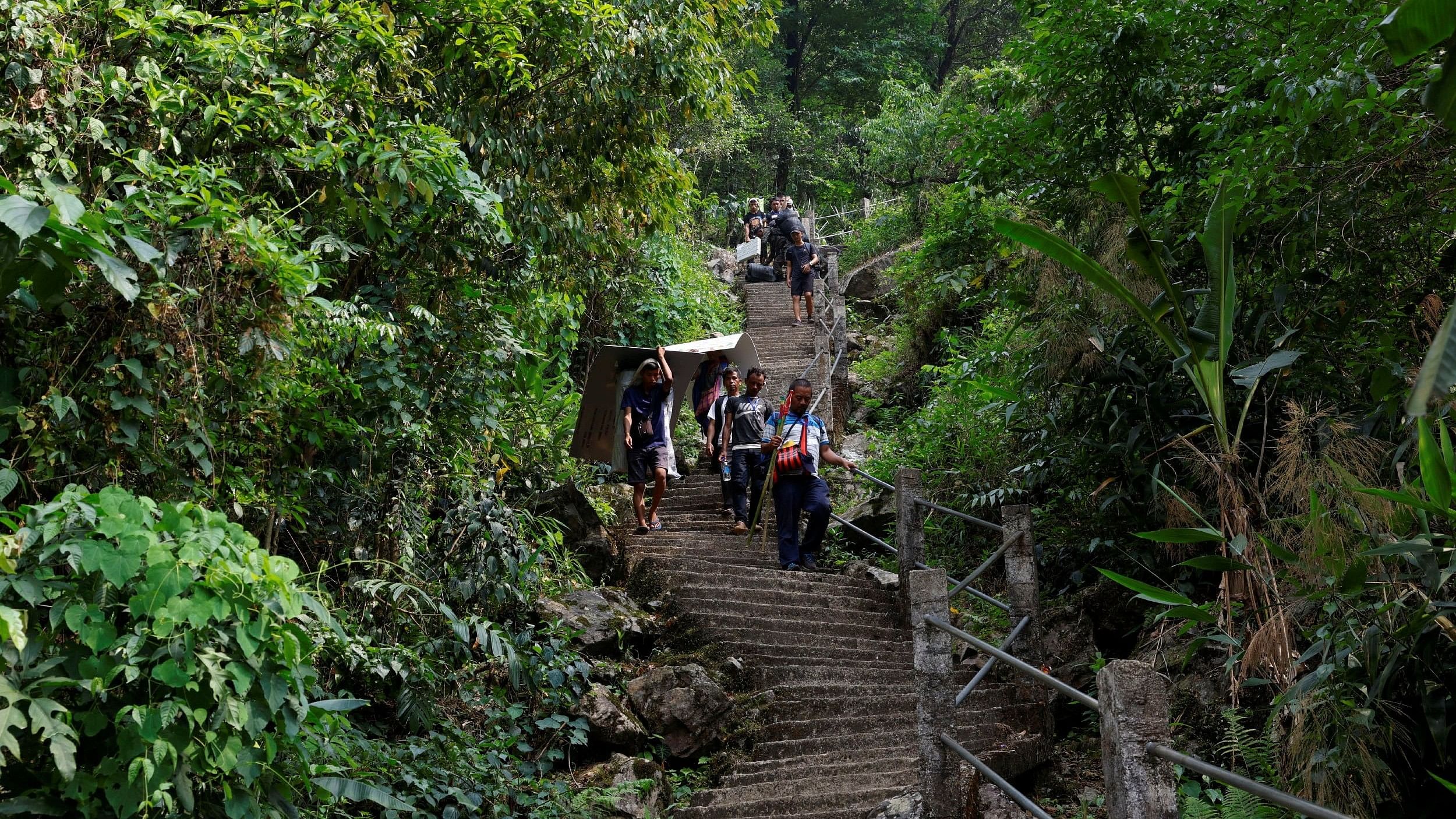 <div class="paragraphs"><p>Polling officers and porters carry Voter Verifiable Paper Audit Trail  as they climb down stairs on a mountain to reach a remote polling station, ahead of the first phase of the election, in Shillong in the northeastern state of Meghalaya, India, April 17, 2024. </p></div>