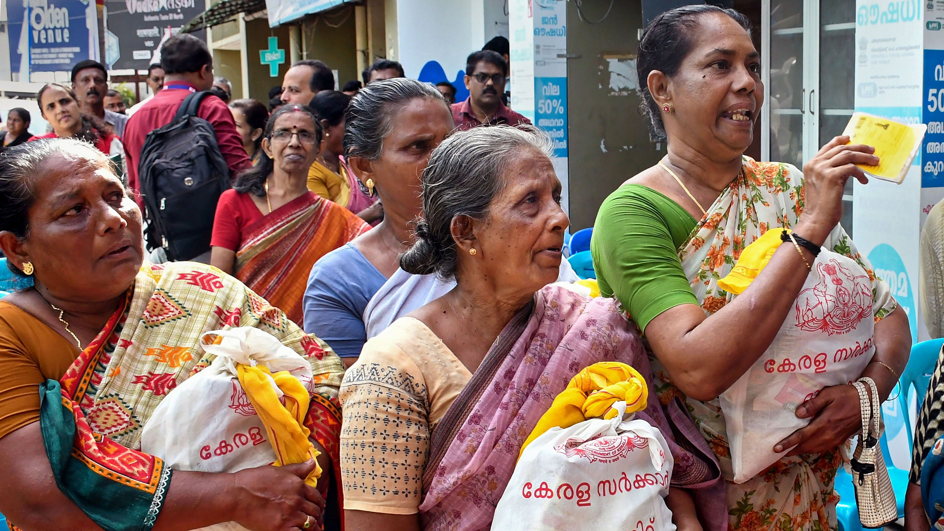 <div class="paragraphs"><p>Women receive food kits distributed by government through ration shops.</p></div>