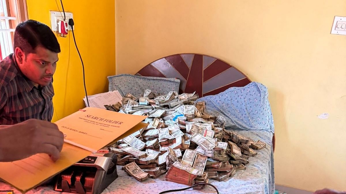 Election officials count cash found inside a house in Yelahanka.