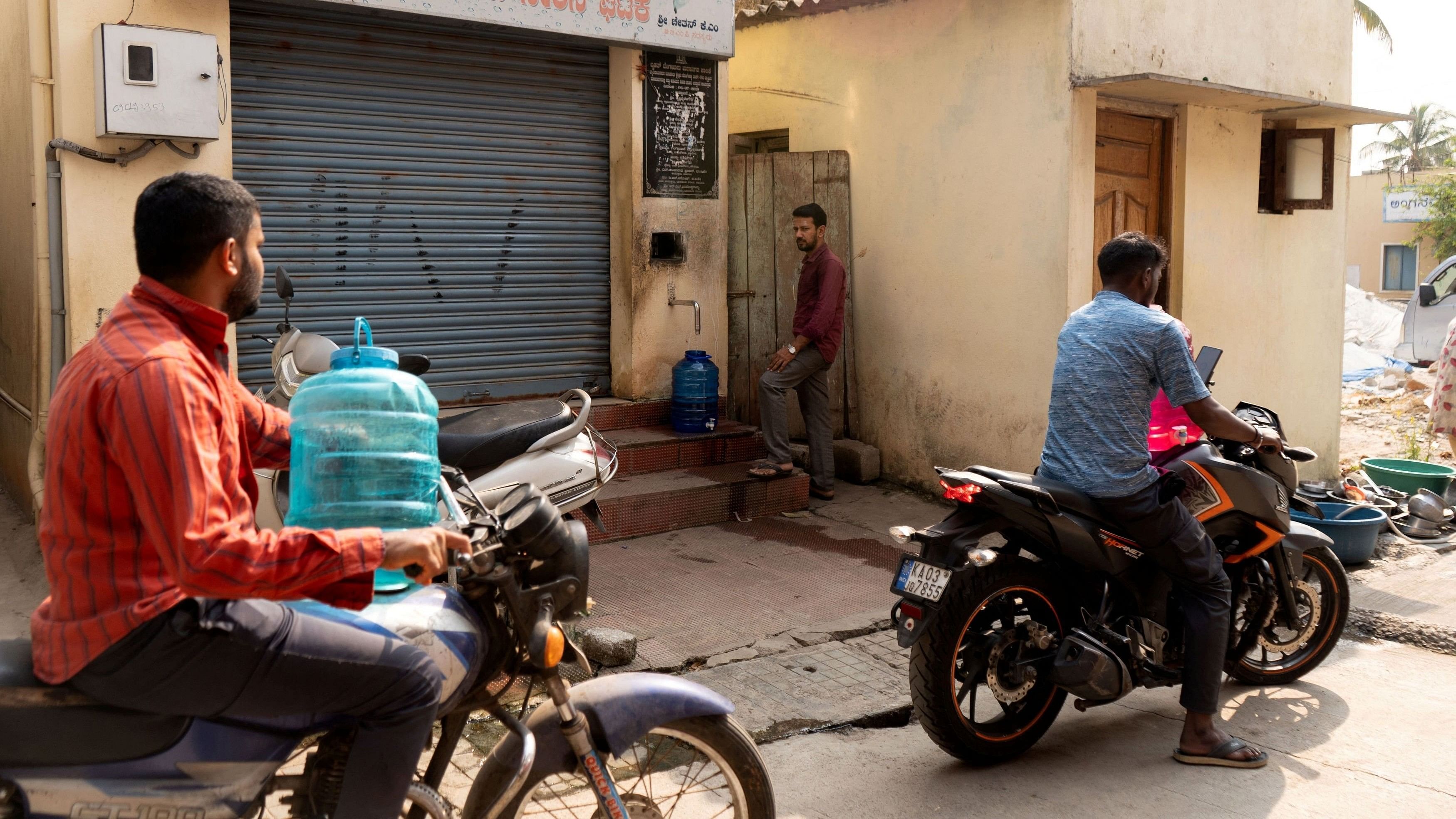 <div class="paragraphs"><p>A resident fills filtered water in a container at a government-run automated self-service water vending machine, as others wait for their turn in a neighbourhood that is facing water scarcity, in the north of Bengaluru, India, March 9, 2024.</p></div>