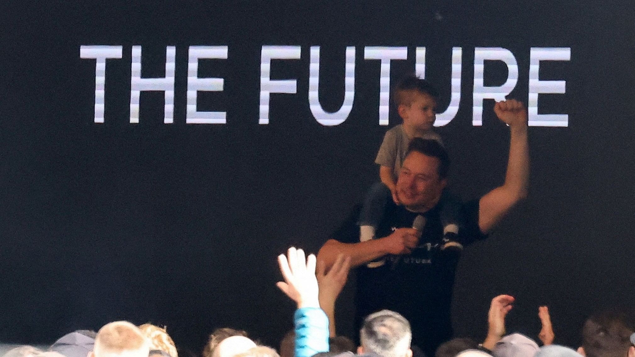 <div class="paragraphs"><p>Tesla CEO Elon Musk gestures with his son X Æ A-12 on his shoulders, as he visits the carmaker's European gigafactory.</p></div>