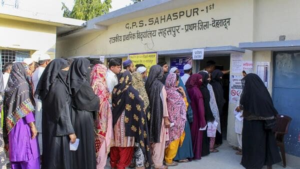 <div class="paragraphs"><p>Voters wait in a queue at a polling station to cast their votes for the first phase of Lok Sabha elections, in Dehradun, Friday, April 19, 2024.</p></div>