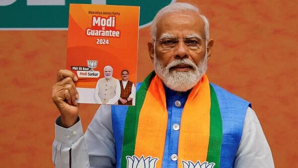 <div class="paragraphs"><p>Prime Minister Narendra Modi displays a copy of the ruling BJP's election manifesto for the general elections, in New Delhi on April 14, 2024. </p></div>
