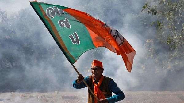 <div class="paragraphs"><p>Supporter of BJP waves his party's flag during celebrations after learning of the initial poll results, in Gandhinagar in 2022.</p></div>