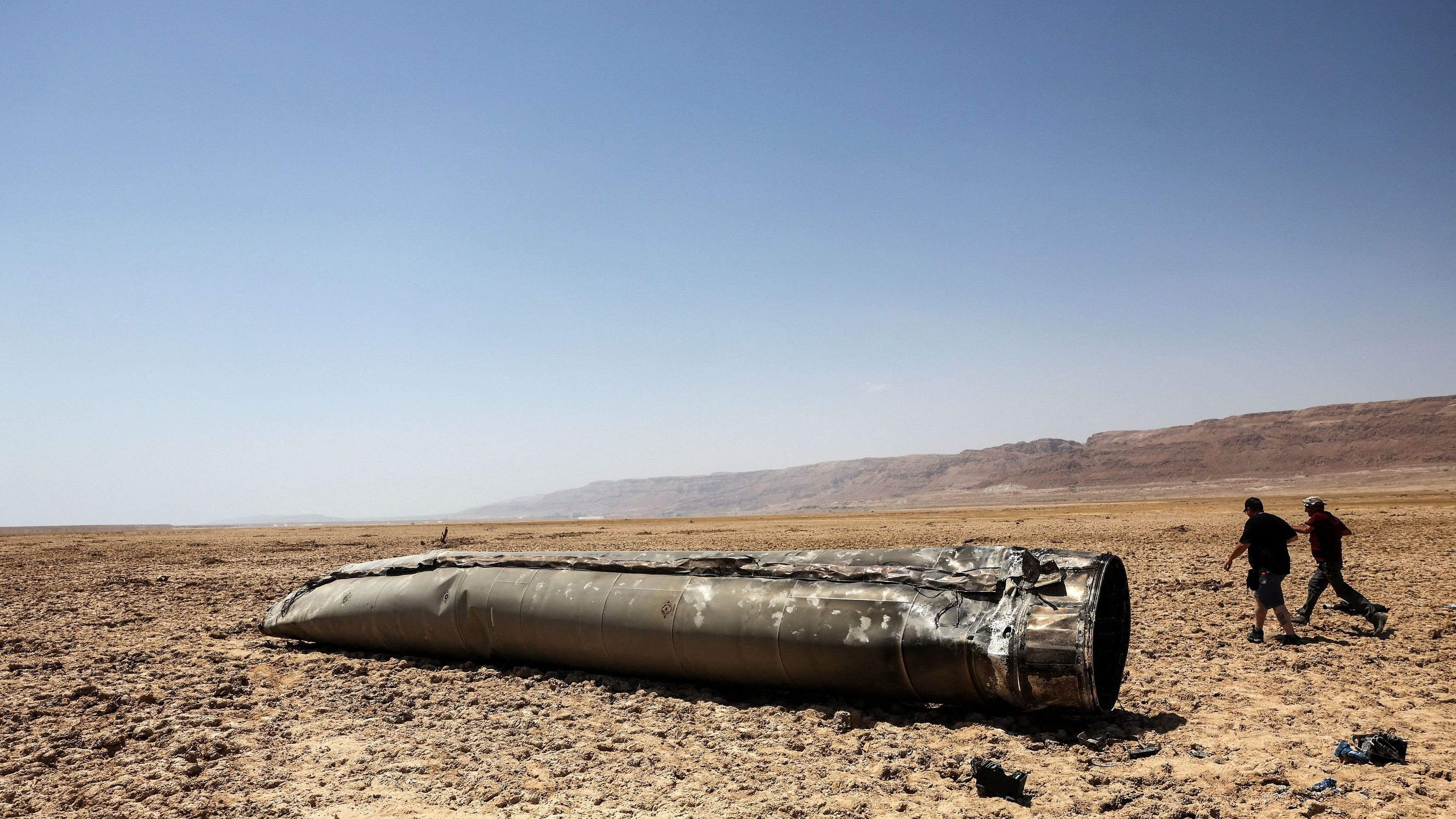 <div class="paragraphs"><p>People walk next to the apparent remains of a ballistic missile, in the desert near the Dead Sea, following a massive missile and drone attack by Iran on Israel, in southern Israel April 21, 2024. </p></div>