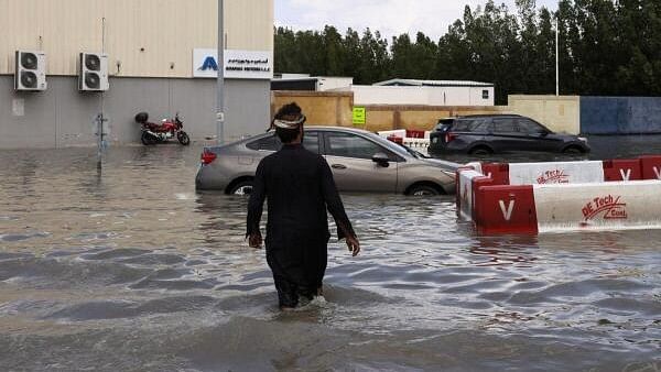 <div class="paragraphs"><p>A person walks towards cars stranded in flood water caused by heavy rains, in Dubai, United Arab Emirates, April 17, 2024.</p></div>