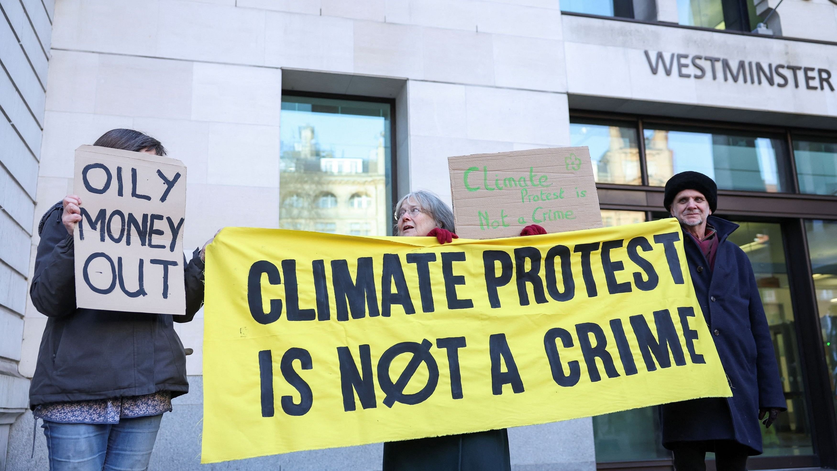 <div class="paragraphs"><p>Climate change protesters hold signs outside Westminster Magistrates' Court in London.</p></div>