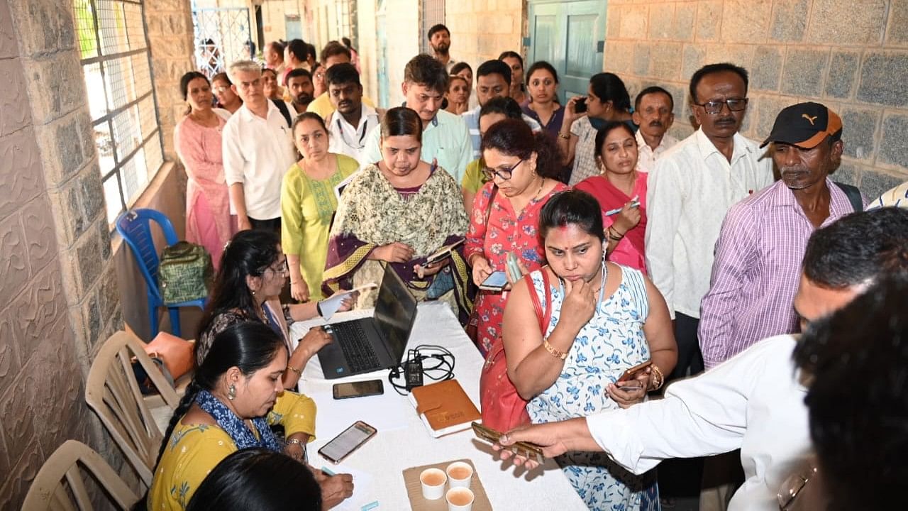 <div class="paragraphs"><p>Polling agents stand in a queue to collect the voting materials in Bengaluru.</p></div>