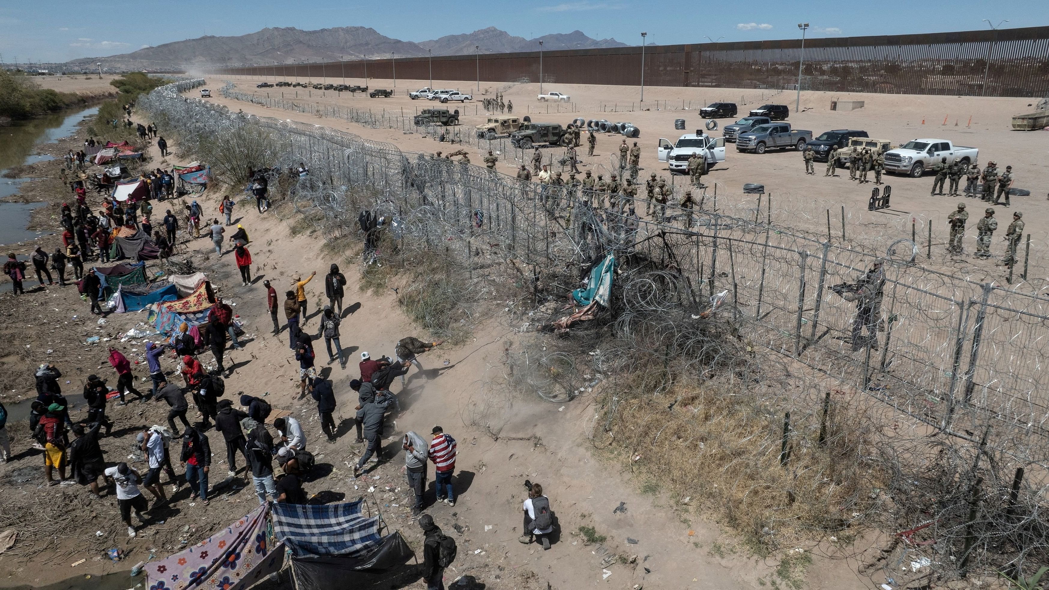 <div class="paragraphs"><p>A drone view shows Texas State Troopers firing projectiles at migrants as they use clothing to remove razor wire which is preventing them from entering the U.S. from along the Rio Grande river in El Paso, Texas, U.S., March 22, 2024.</p></div>