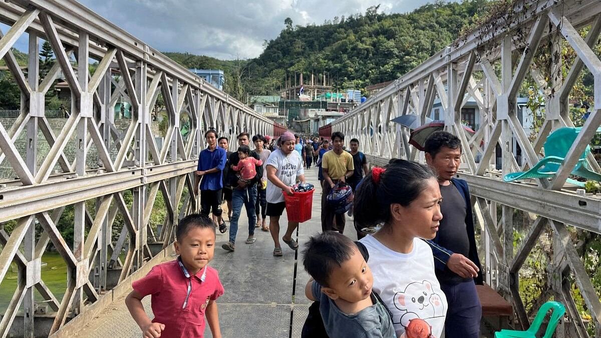 <div class="paragraphs"><p>People who fled Myanmar cross a bridge that connects Myanmar and India at the border village of Zokhawthar.</p></div>