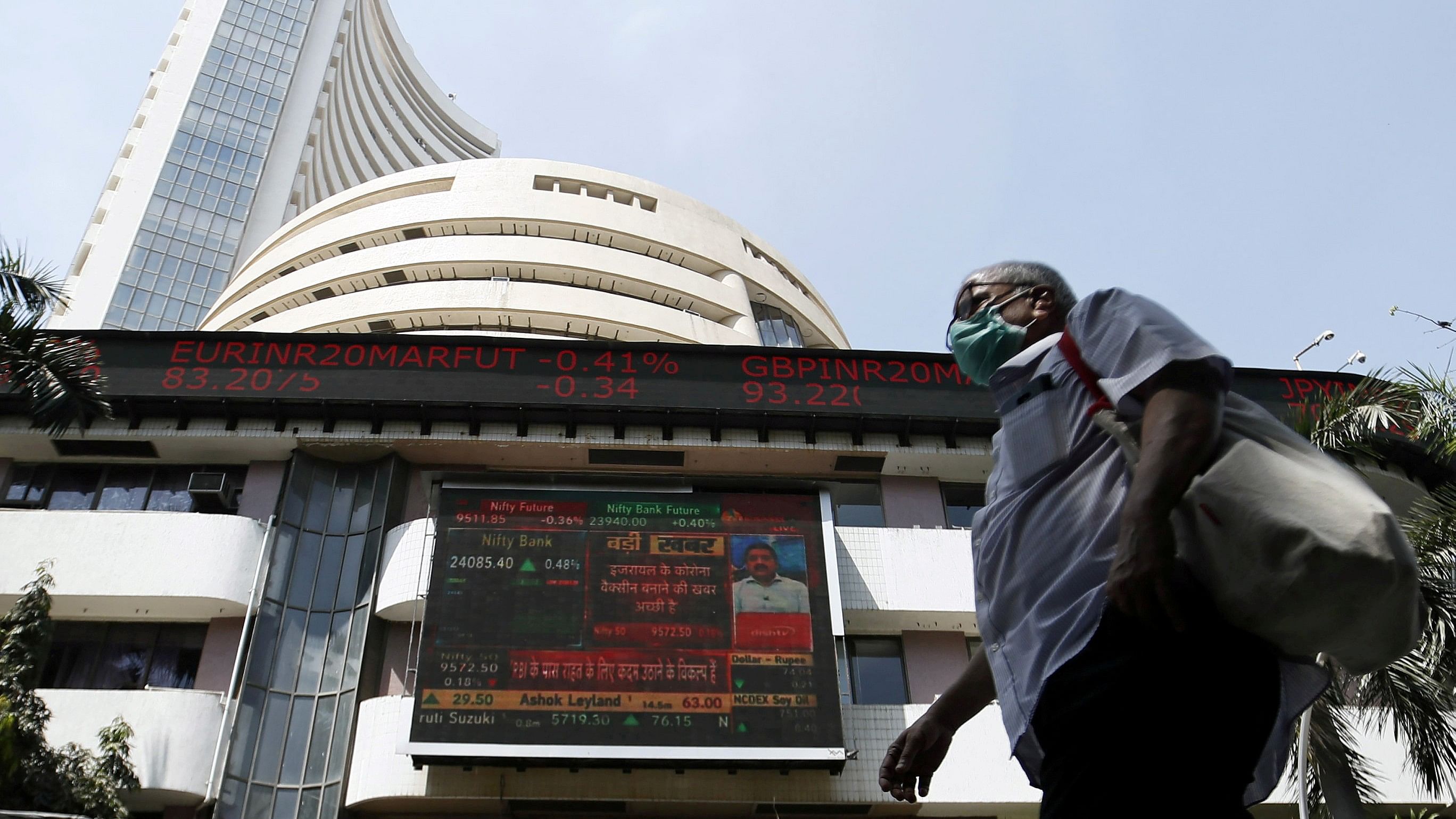 <div class="paragraphs"><p>File photo of&nbsp;A man wearing a protective mask walks past the Bombay Stock Exchange (BSE) building in Mumbai</p></div>