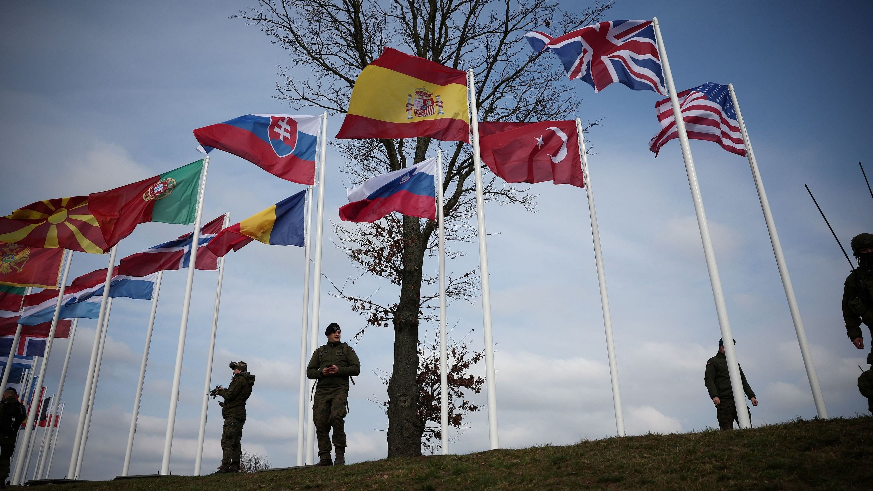 <div class="paragraphs"><p>Soldiers stand near the flags of NATO countries during NATO Dragon-24, part of the Steadfast Defender 2024 exercise, in Korzeniewo, Poland, March 4, 2024. </p></div>