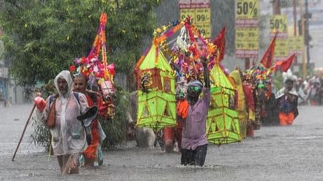 <div class="paragraphs"><p>Lord Shiva devotees or 'Kanwariyas' carrying holy water from the Ganga river wade through a waterlogged road amid monsoon rainfall during their pilgrimage in the month of 'Shravan', in Haridwar</p></div>