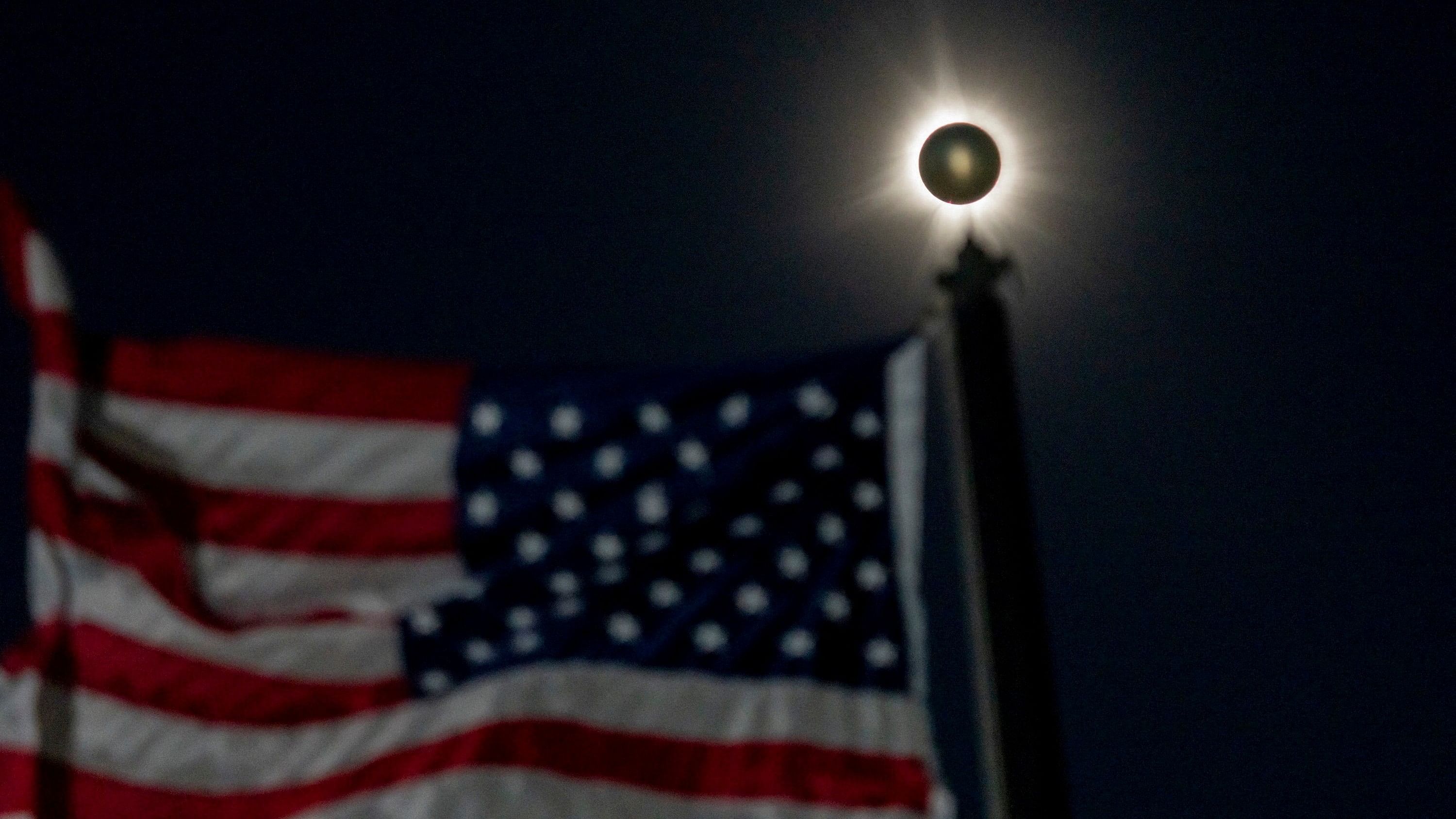 <div class="paragraphs"><p>A total solar eclipse is seen beside a waving American flag in Houlton, Maine.</p></div>