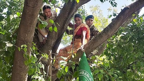 <div class="paragraphs"><p>Security personnel try to bring down a farmer after she climbed a tree during a protest of farmers from Tamil Nadu, at Jantar Mantar, in New Delhi, Wednesday, April 24, 2024. </p></div>
