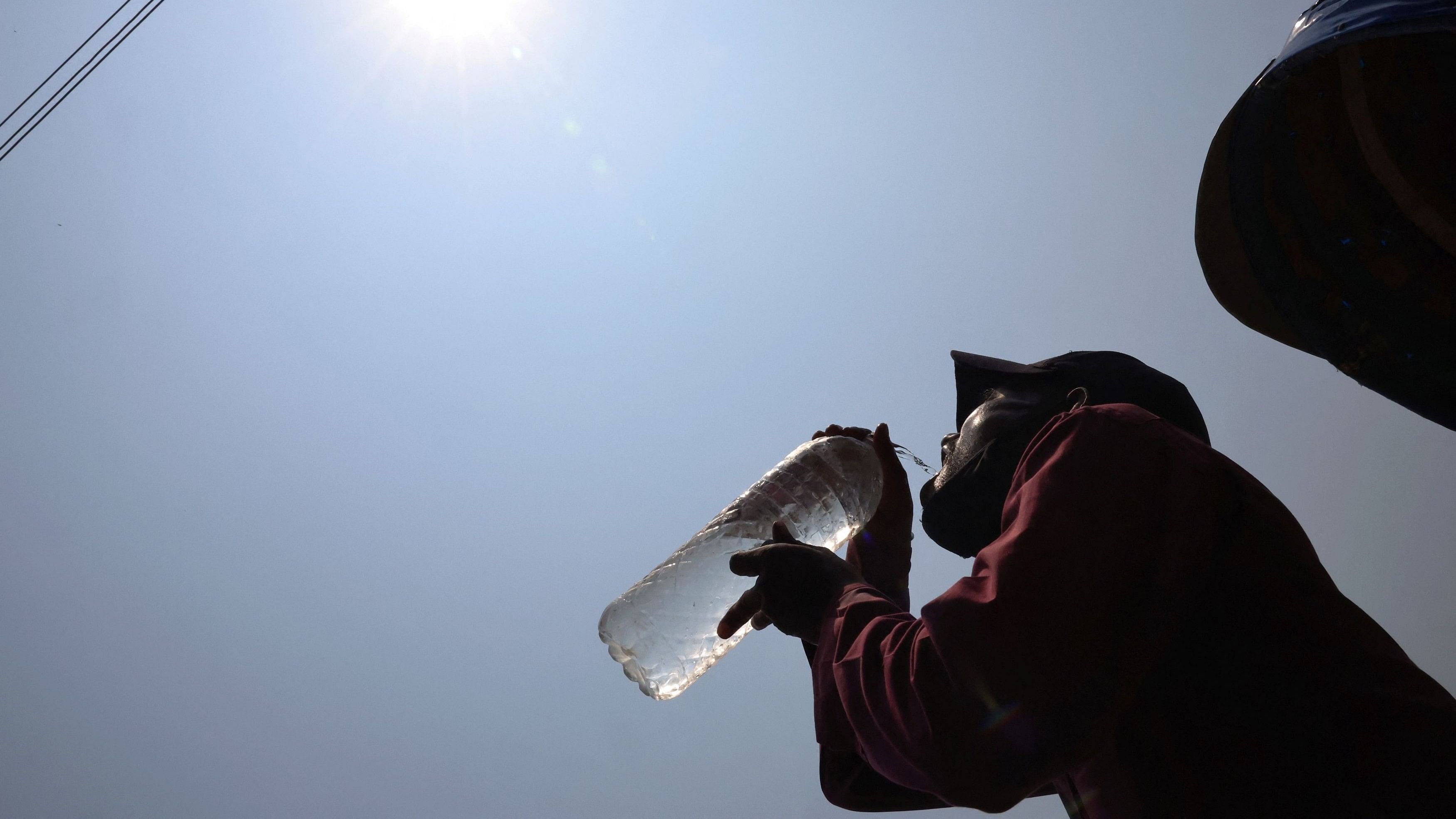 <div class="paragraphs"><p>A man drinks cold water at noon during a heatwave. </p></div>