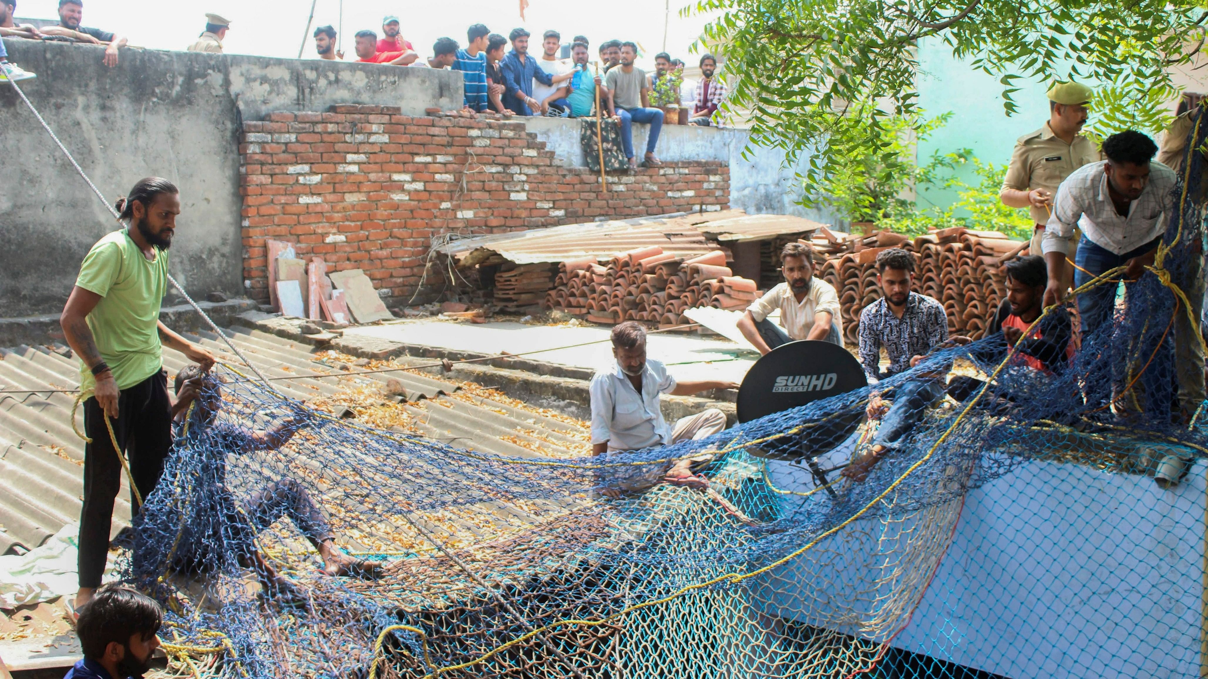 <div class="paragraphs"><p>Locals at the spot after a leopard entered a house, in Meerut, Saturday, April 13, 2024. </p></div>