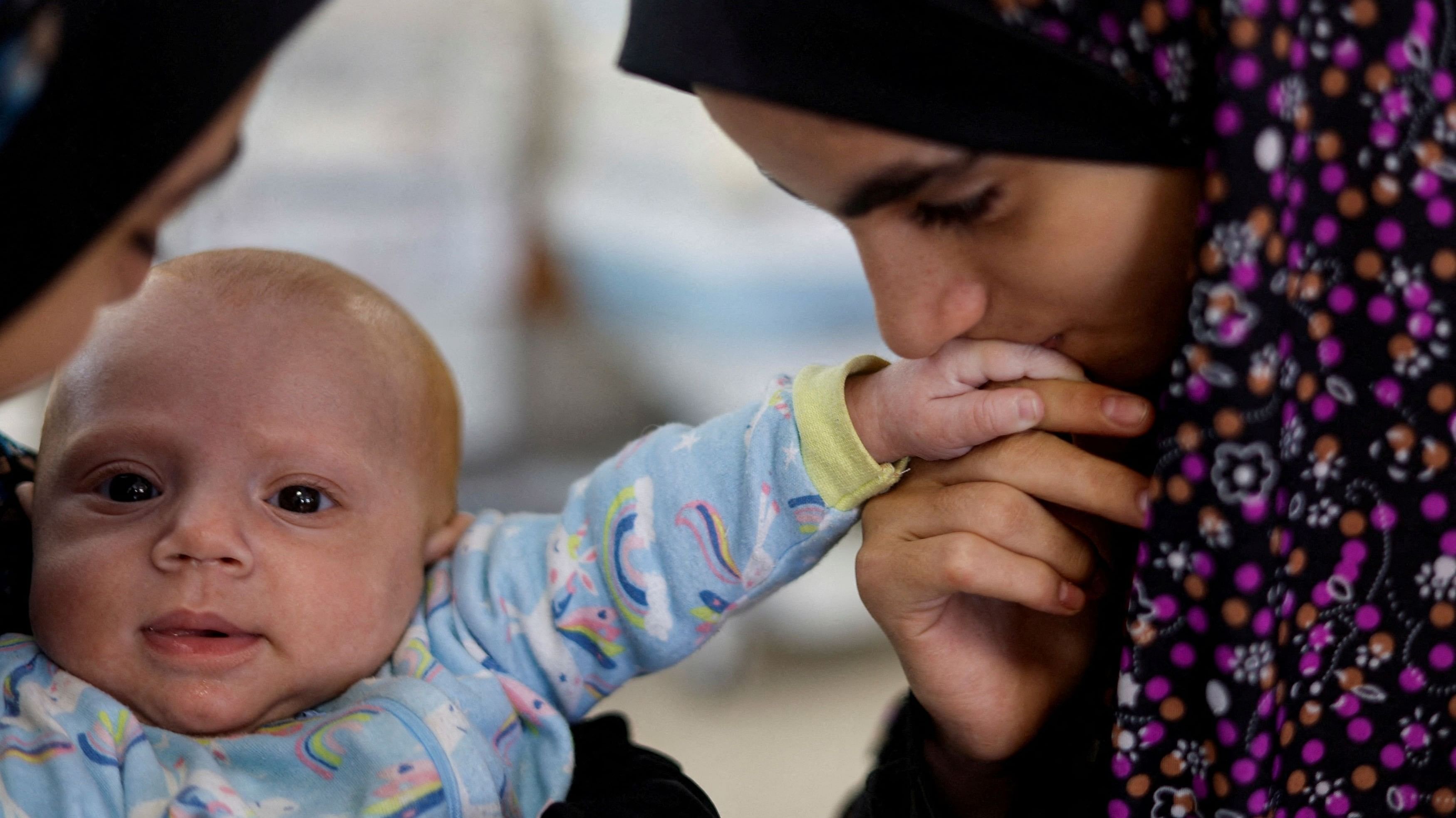 <div class="paragraphs"><p>A girl kisses the hand of Yehia Hamuda, a Palestinian infant, who was evacuated to south Gaza as a premature baby after Israeli forces raided Kamal Adwan hospital in northern Gaza Strip and is currently separated from his parents due to an Israeli checkpoint that separates north Gaza from the south, at Al-Emirati hospital, in Rafah in the southern Gaza Strip, April 24, 2024.</p></div>