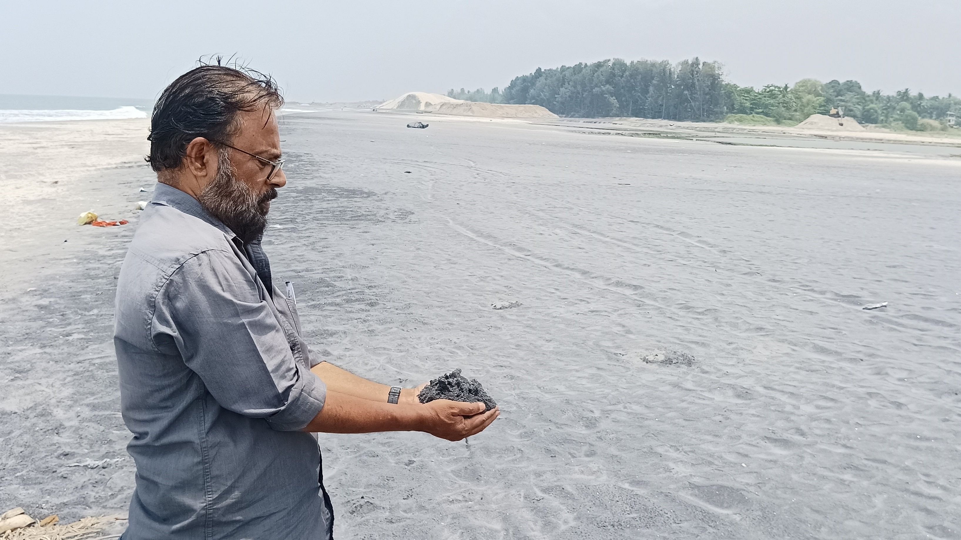 <div class="paragraphs"><p>Chairman of the anti-mining action council at Thottappally Suresh Kumar showing the mineral rich sand.</p></div>