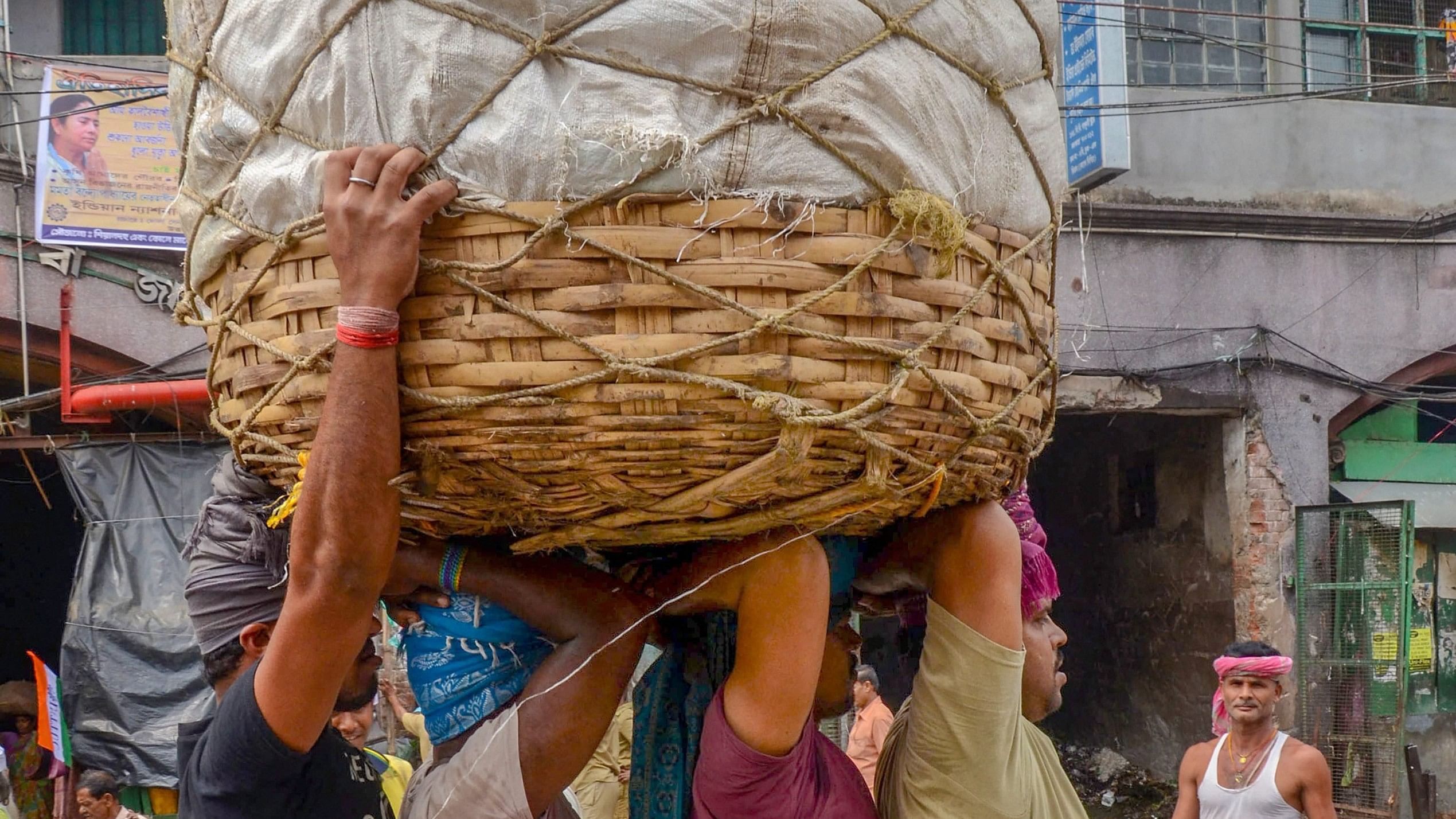<div class="paragraphs"><p>Workers carry a basket on their heads at a wholesale market, in Kolkata. Representative image</p></div>