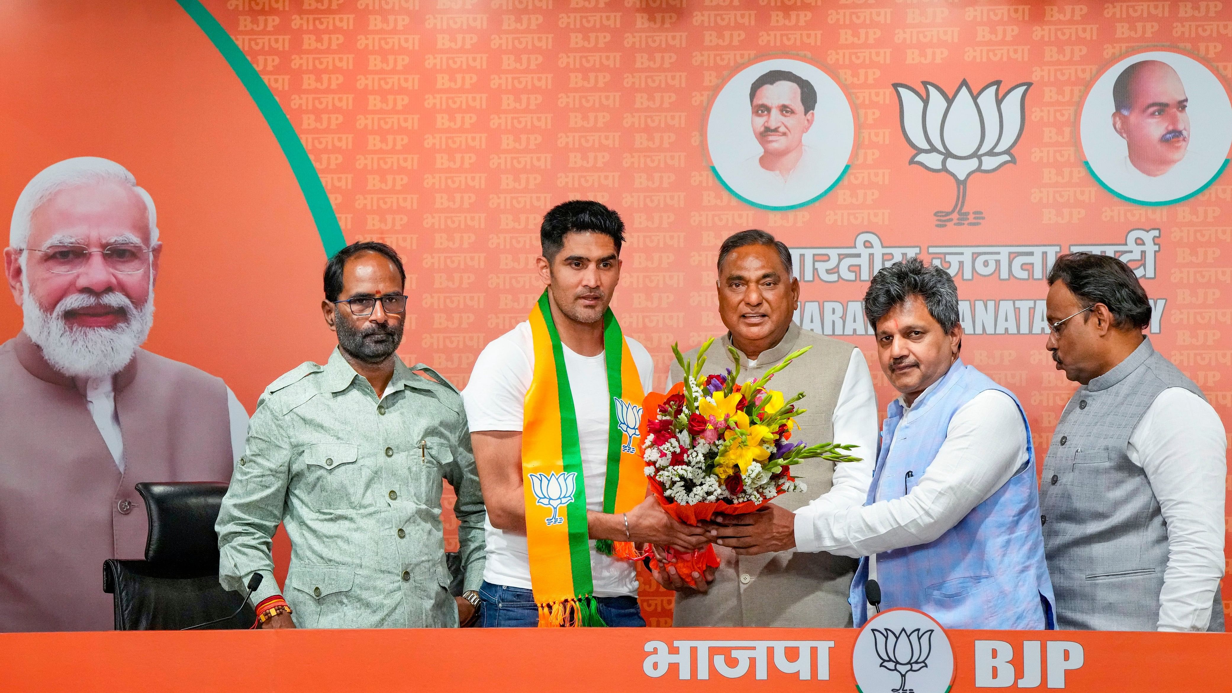 <div class="paragraphs"><p>Boxer and former Congress leader Vijender Singh being greeted by BJP leader Ramvir Singh Bidhuri as he joins the party ahead of Lok Sabha elections, at BJP HQ in New Delhi, Wednesday, April 3, 2024. </p></div>