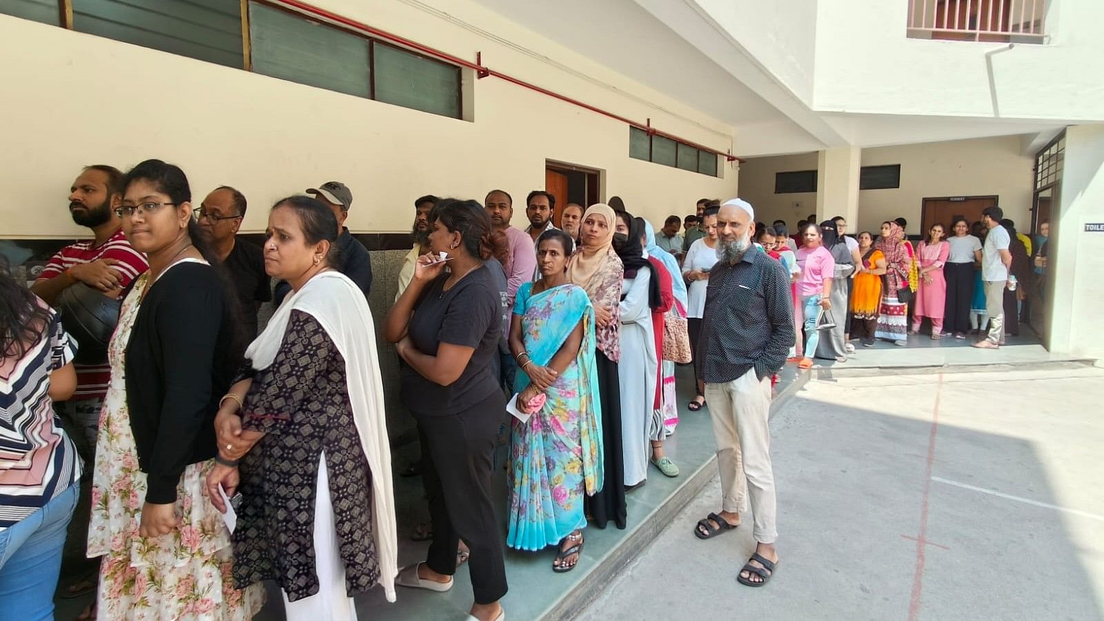 <div class="paragraphs"><p>People stand in line to cast their votes for the&nbsp;Lok Sabha elections at the Royal School booth in Bengaluru </p></div>