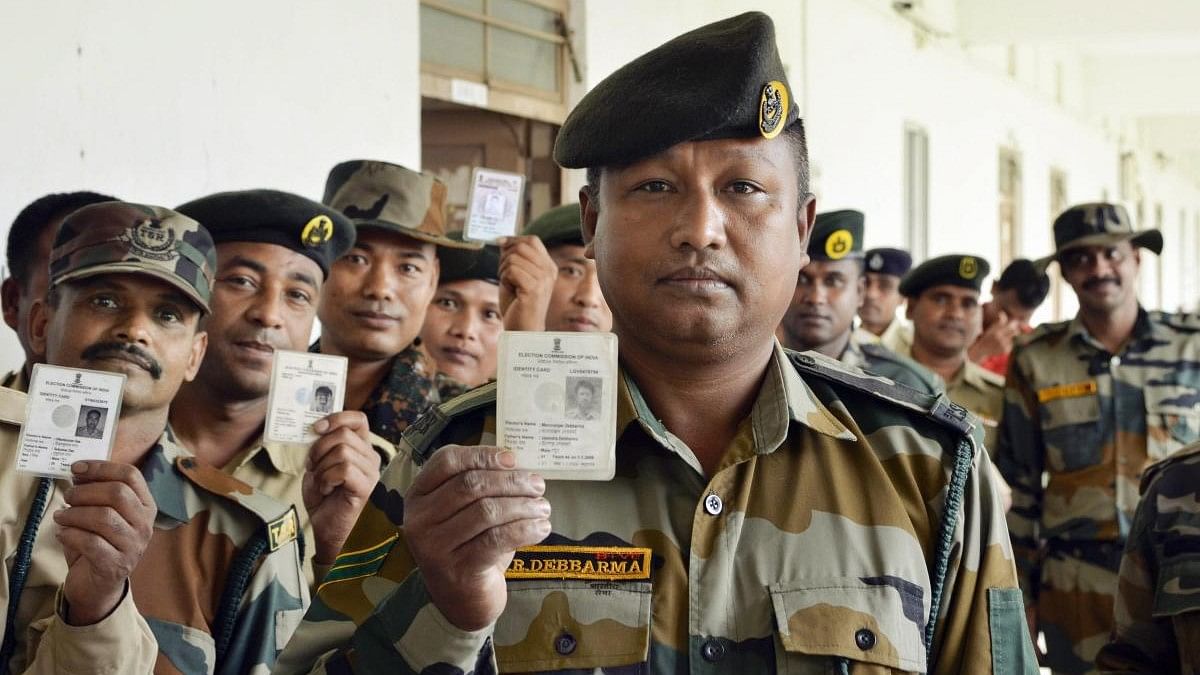 <div class="paragraphs"><p>Tripura State Rifles personnel show their voter identity cards before casting their votes.</p></div>