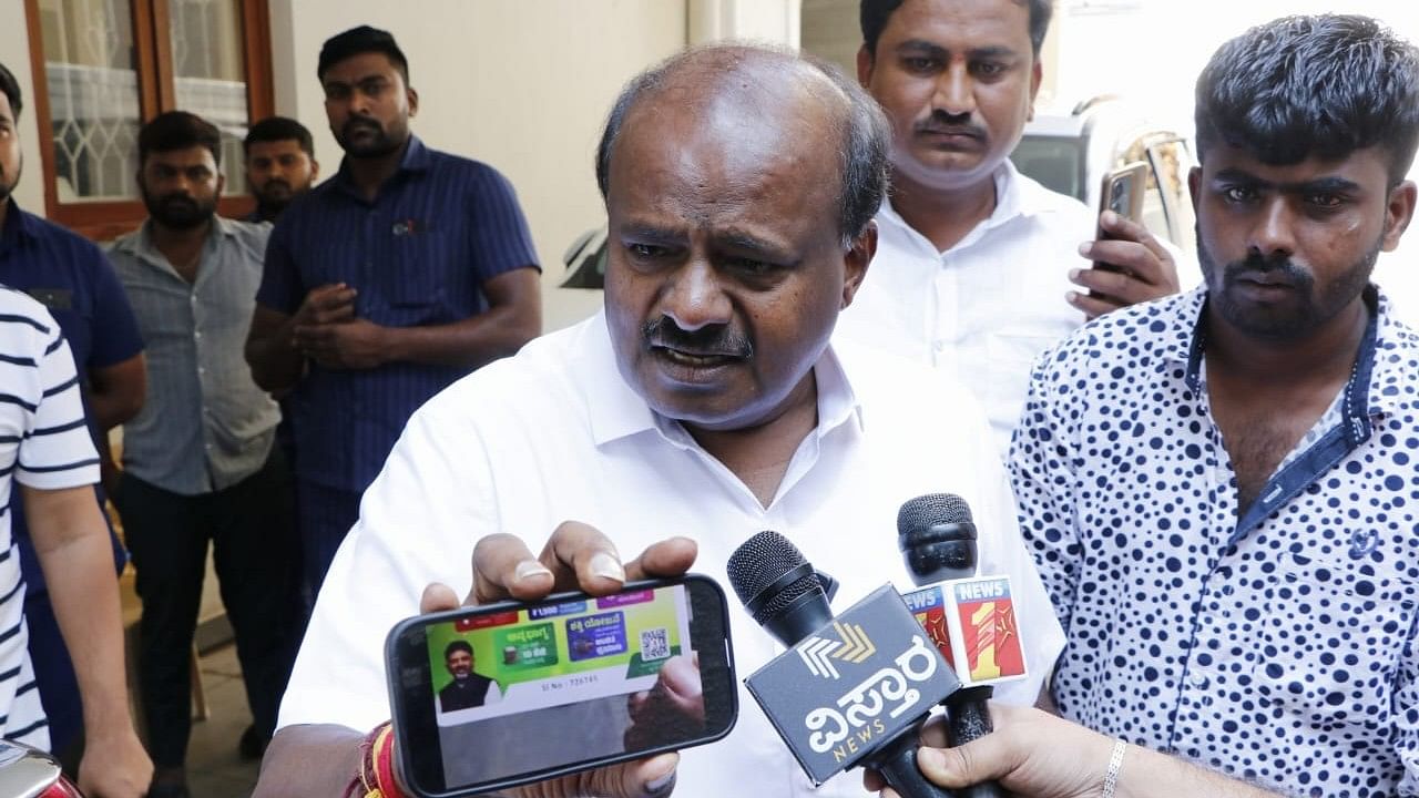 <div class="paragraphs"><p>Kumaraswamy shows a 'guft card' given out by Congress on a mobile phone.&nbsp;</p></div>