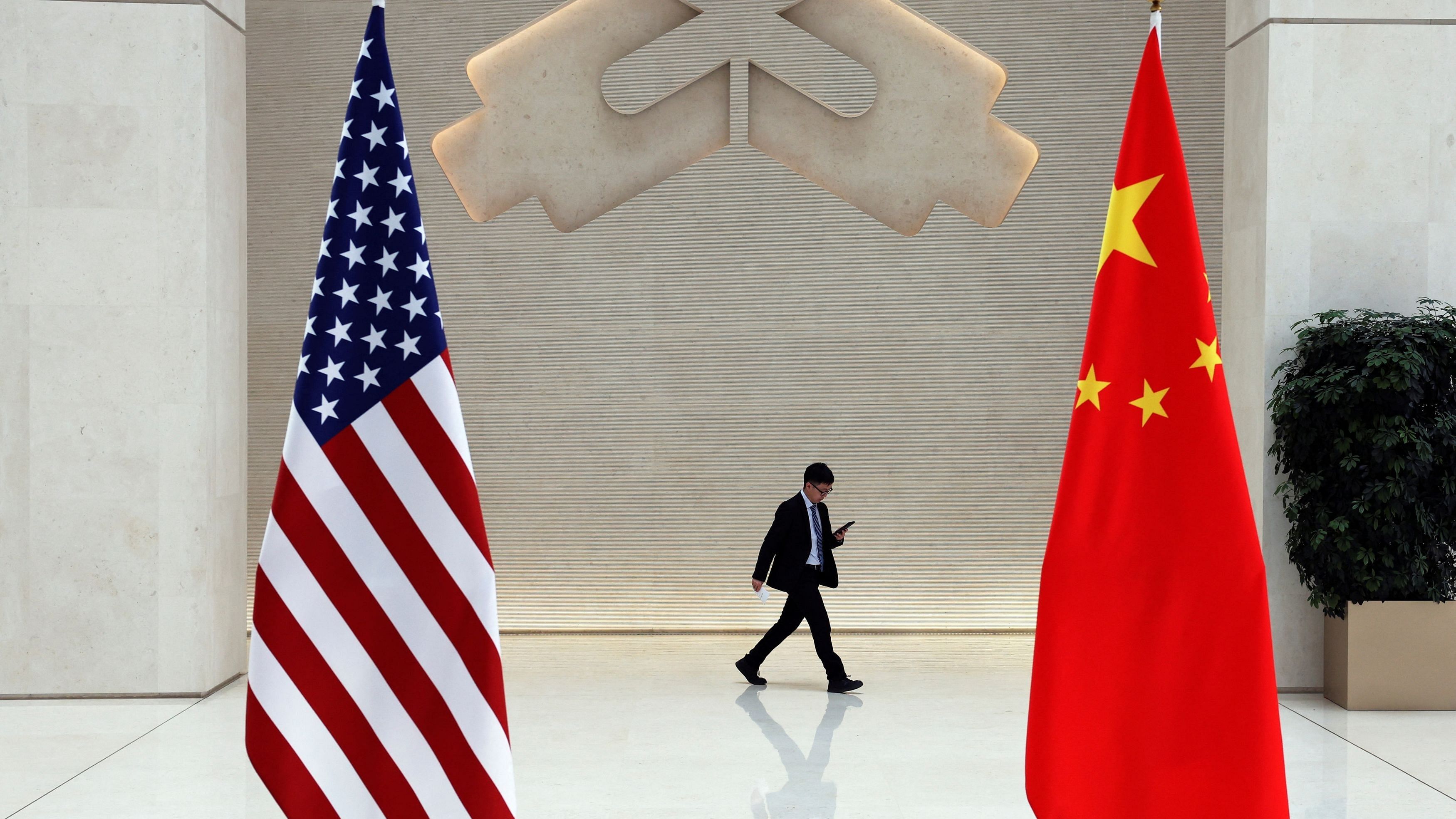 <div class="paragraphs"><p>A man walks past U.S. and Chinese flags</p></div>