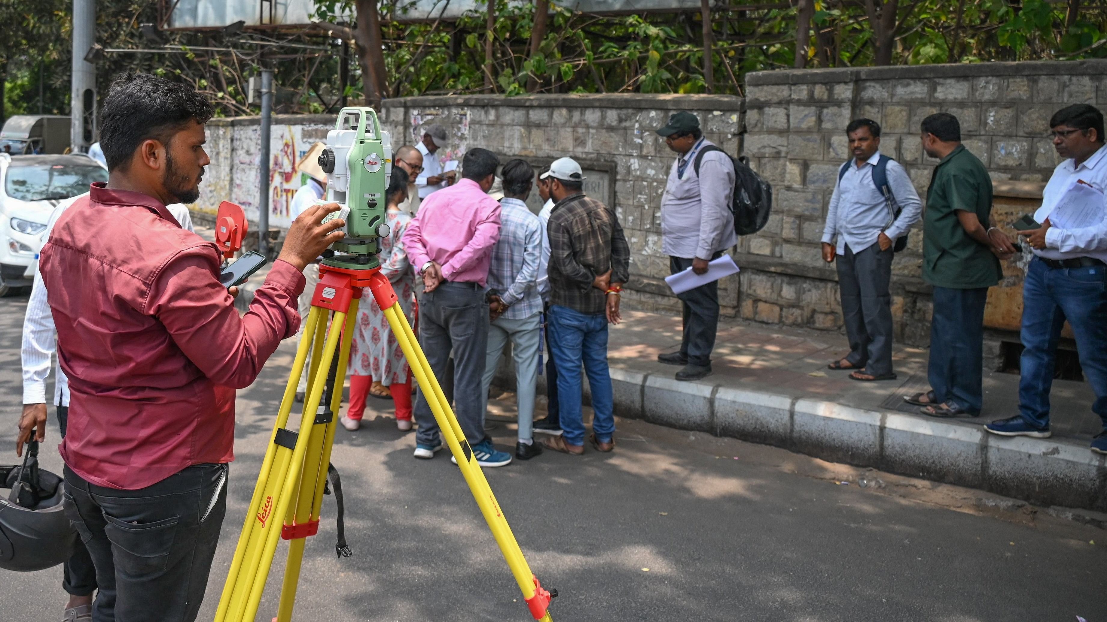 <div class="paragraphs"><p>BBMP workers undertake a land survey near Mekhri Circle on Friday.&nbsp;</p></div>