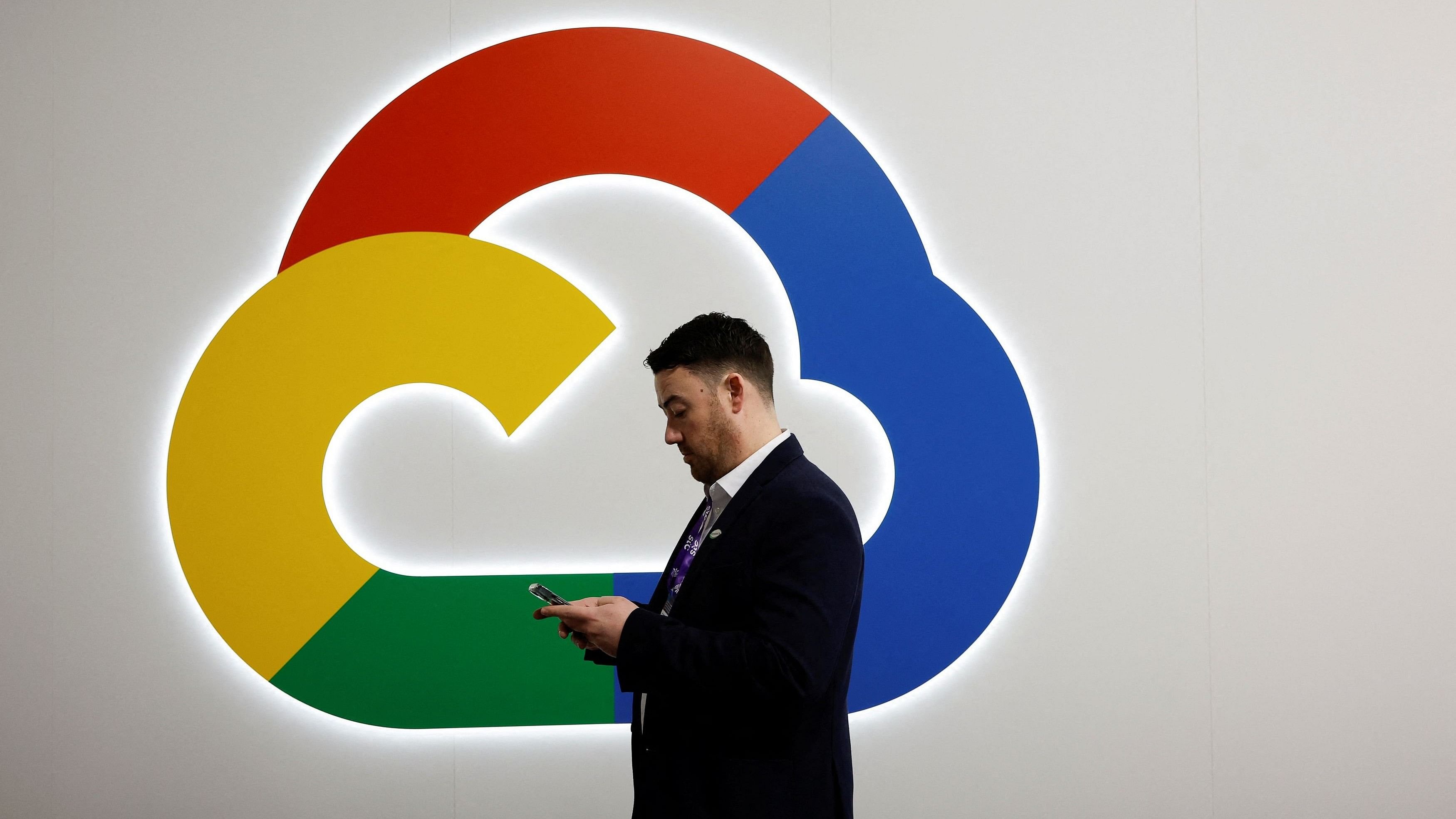 <div class="paragraphs"><p>A person looks at their phone in front of the Google Cloud logo.</p></div>