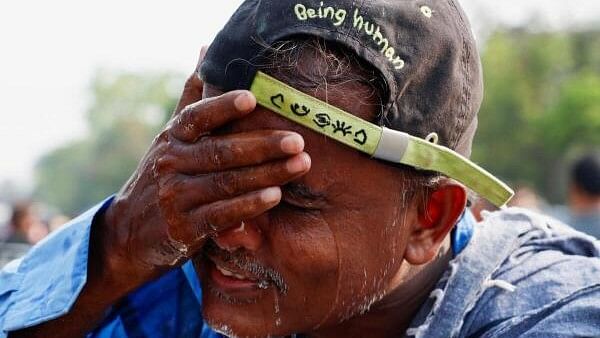 <div class="paragraphs"><p>A man washes his face with water on a hot summer day at a market in Kolkata</p></div>