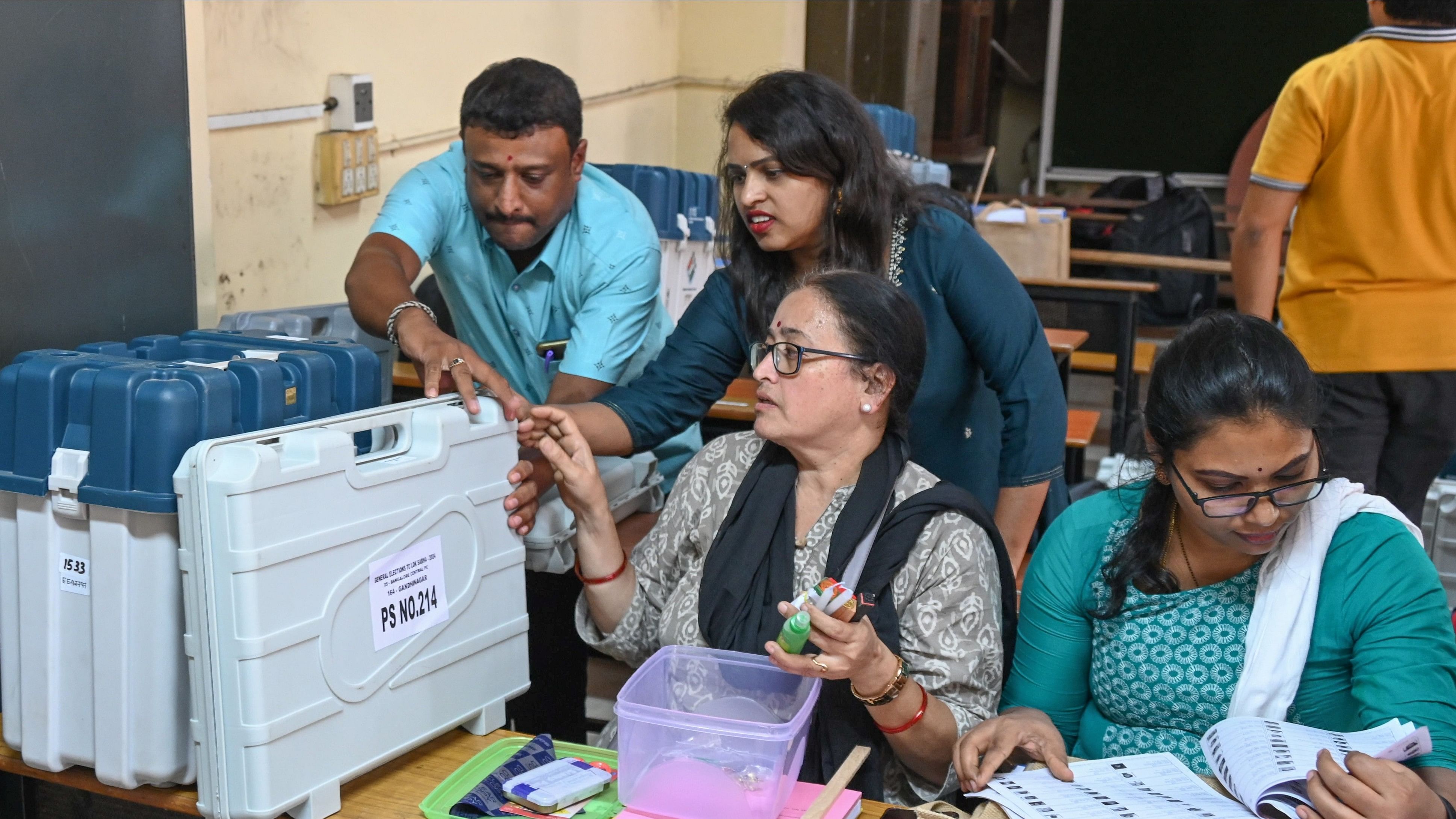 Polling officials inspect election materials at the mustering centre in Bengaluru on Thursday. DH PHOTO/S K Dinesh &amp; B K Janardhan