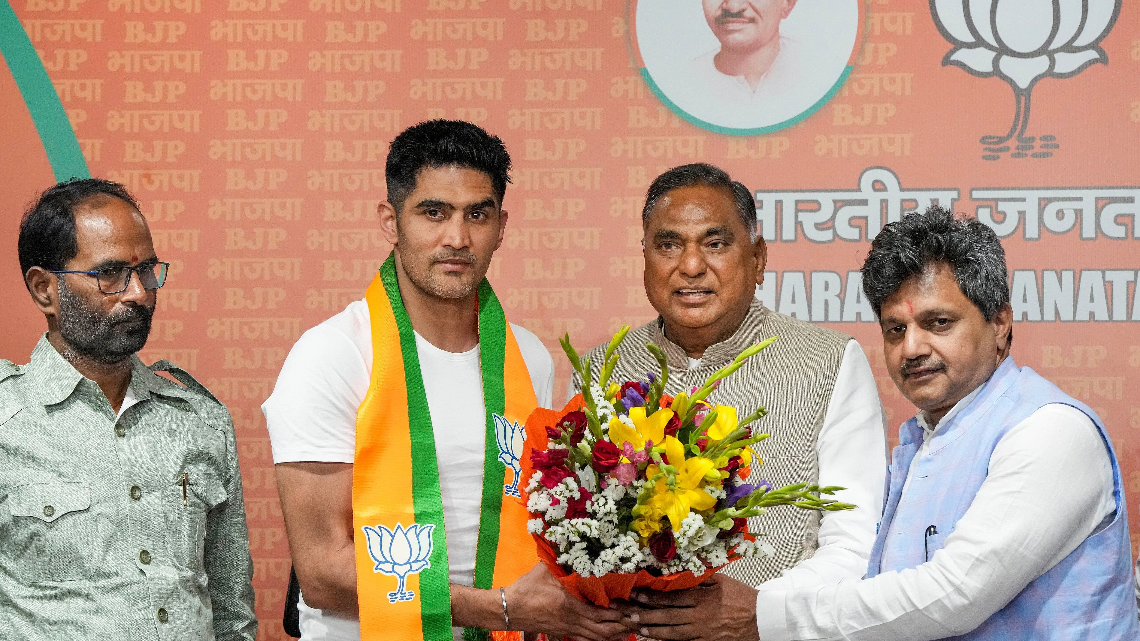 <div class="paragraphs"><p> Boxer and former Congress leader Vijender Singh being greeted by BJP leader Ramvir Singh Bidhuri as he joins the party ahead of Lok Sabha elections, at BJP HQ in New Delhi on Wednesday, April 3, 2024.</p></div>