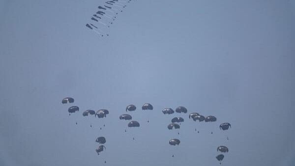 <div class="paragraphs"><p>Humanitarian aid falls through the sky towards the Gaza Strip after being dropped from an aircraft, as seen from Israel.</p></div>