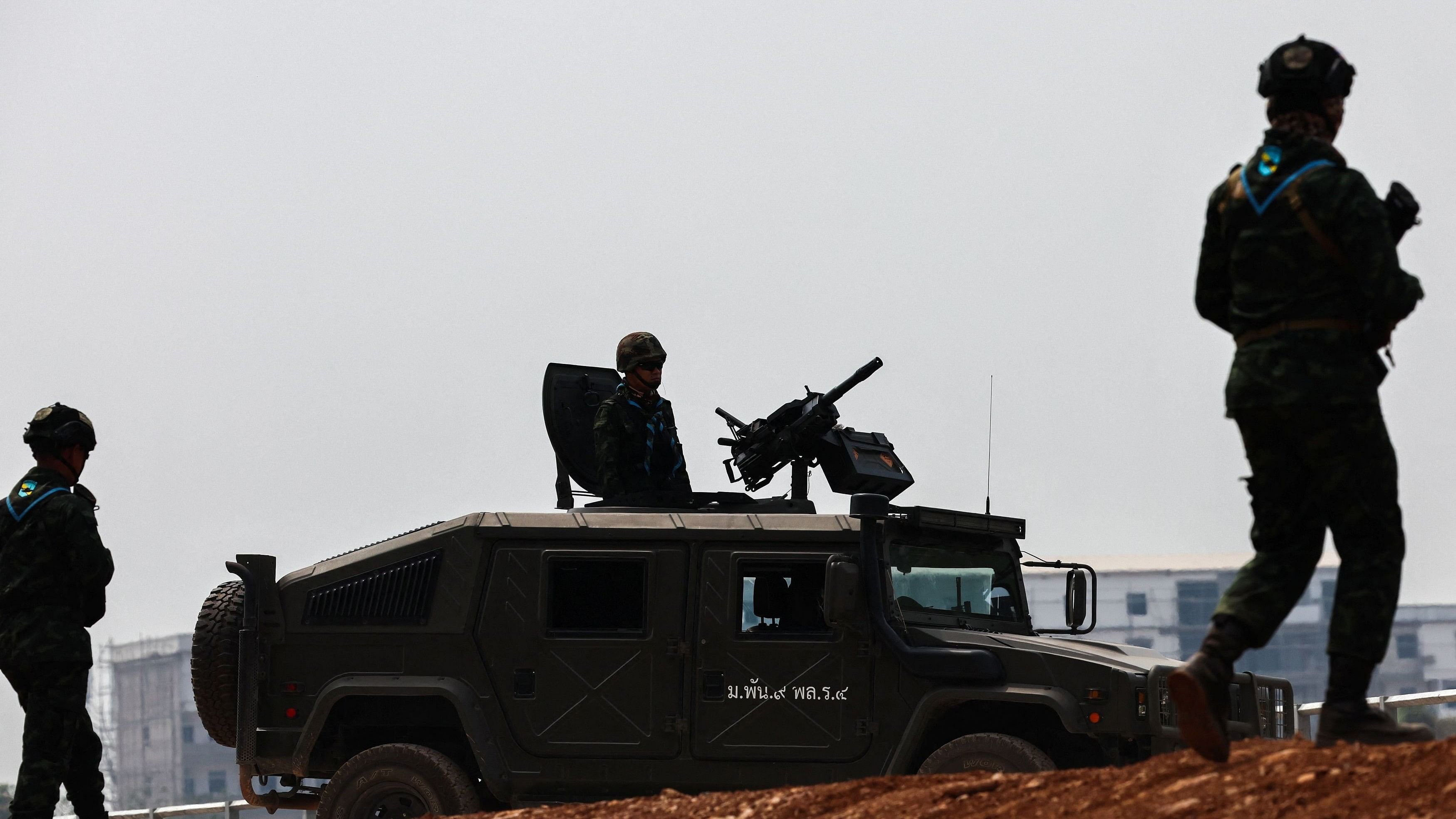 <div class="paragraphs"><p>Military personnel stand guard, as a stream of people, some of them fearing air strikes, queued at a border crossing to flee Myanmar early on Friday, a day after the strategically-vital town of Myawaddy adjoining Thailand fell to anti-junta resistance that has been growing in strength, in Mae Sot, Tak province, Thailand, April 12, 2024. </p></div>