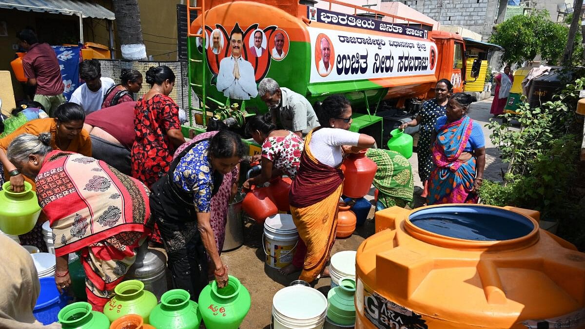 <div class="paragraphs"><p>People gather to collect water from a tanker due to the ongoing water crisis, at Bangarappanagar in Bengaluru.</p></div>