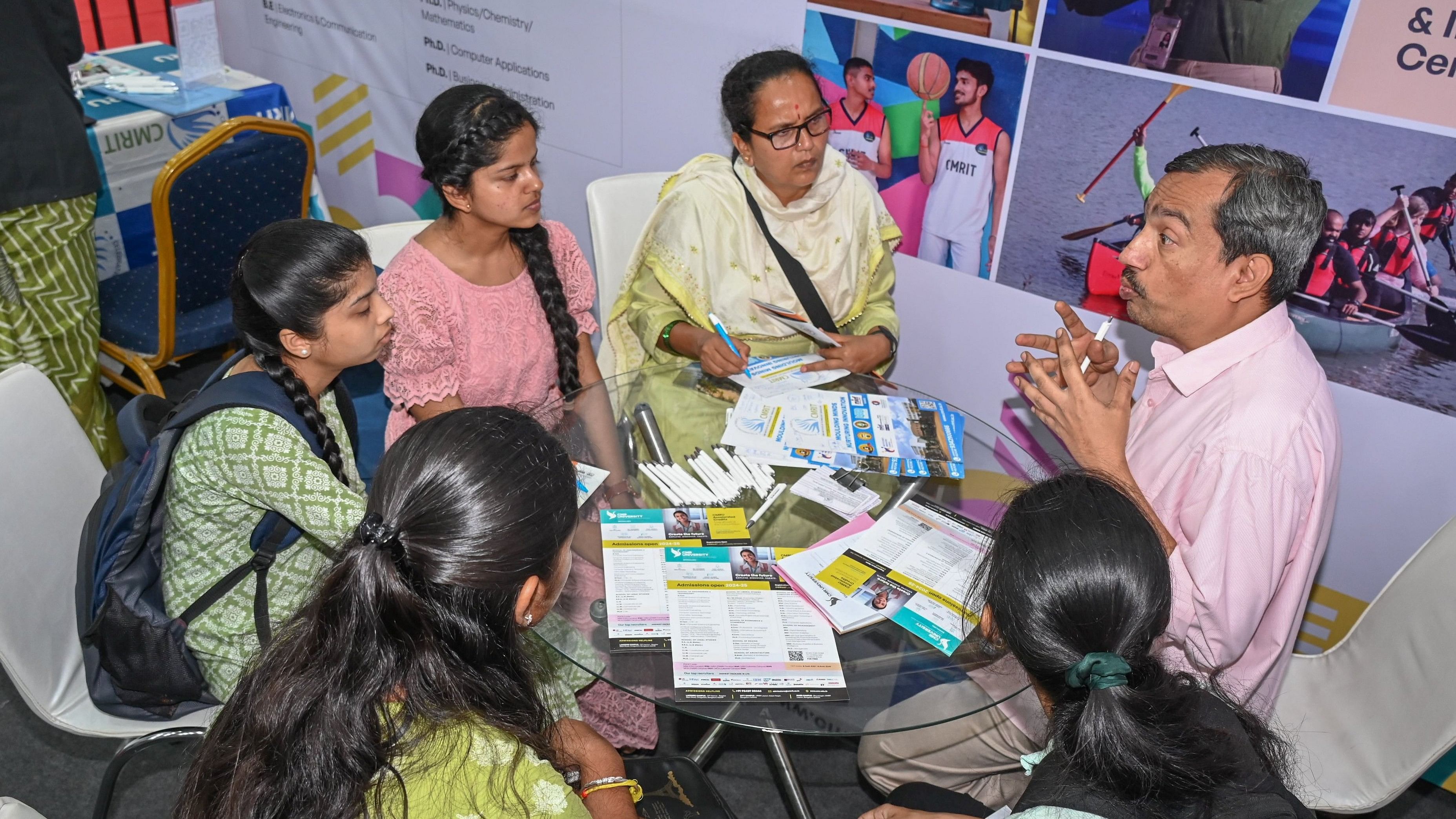 <div class="paragraphs"><p>A staffer at a stall gives in-depth explanation about courses on offer at the exhibition. </p></div>