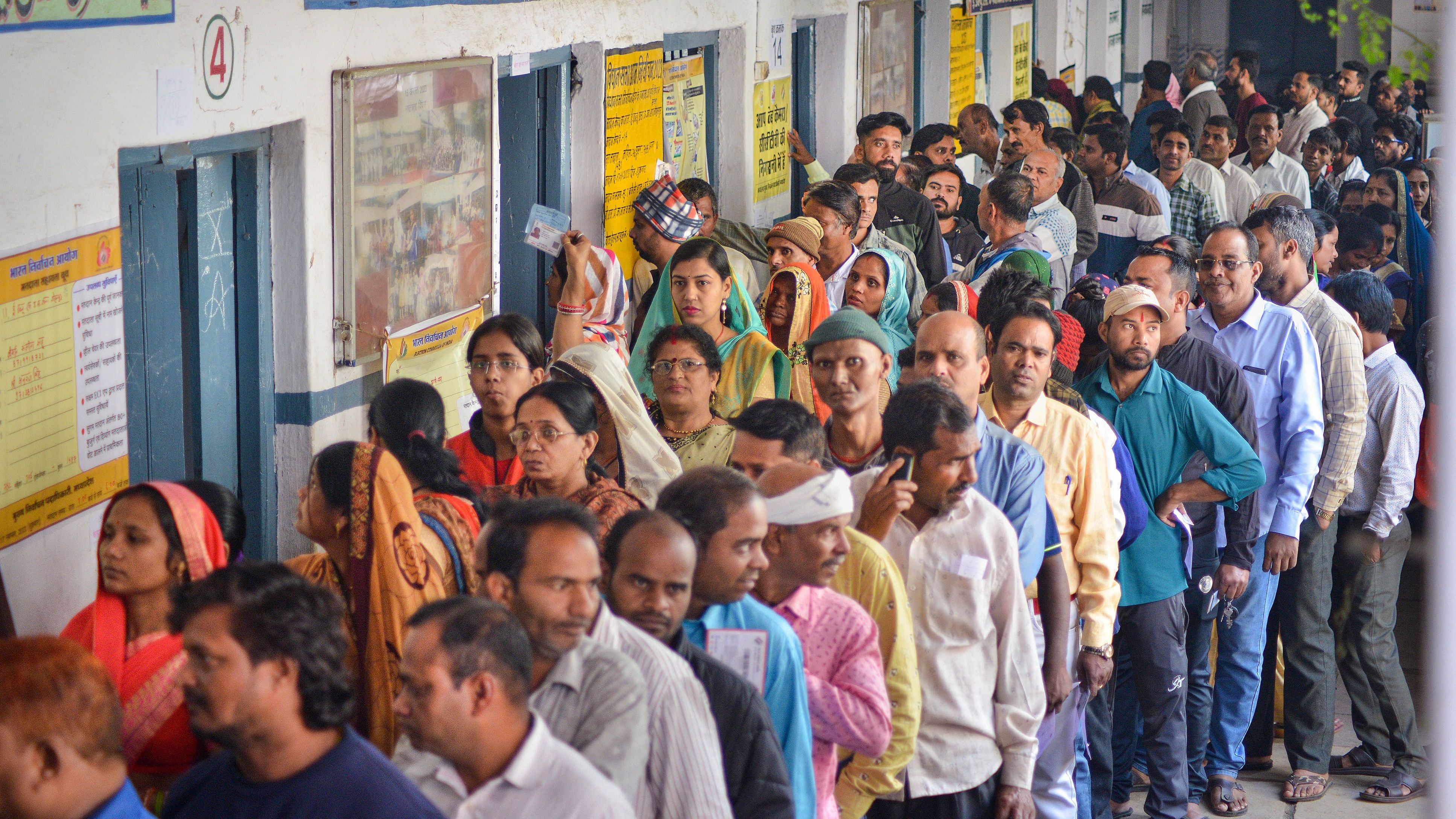 <div class="paragraphs"><p>Voters wait in a queue at a polling station to cast their votes.</p></div>