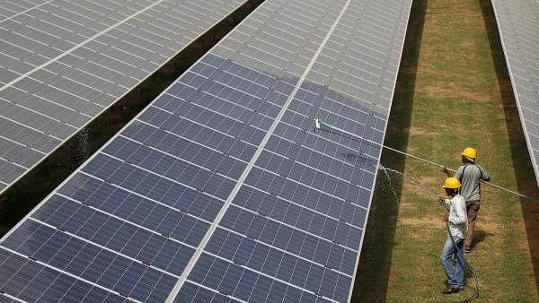 <div class="paragraphs"><p>Workers clean photovoltaic panels inside a solar power plant in Gujarat.</p></div>