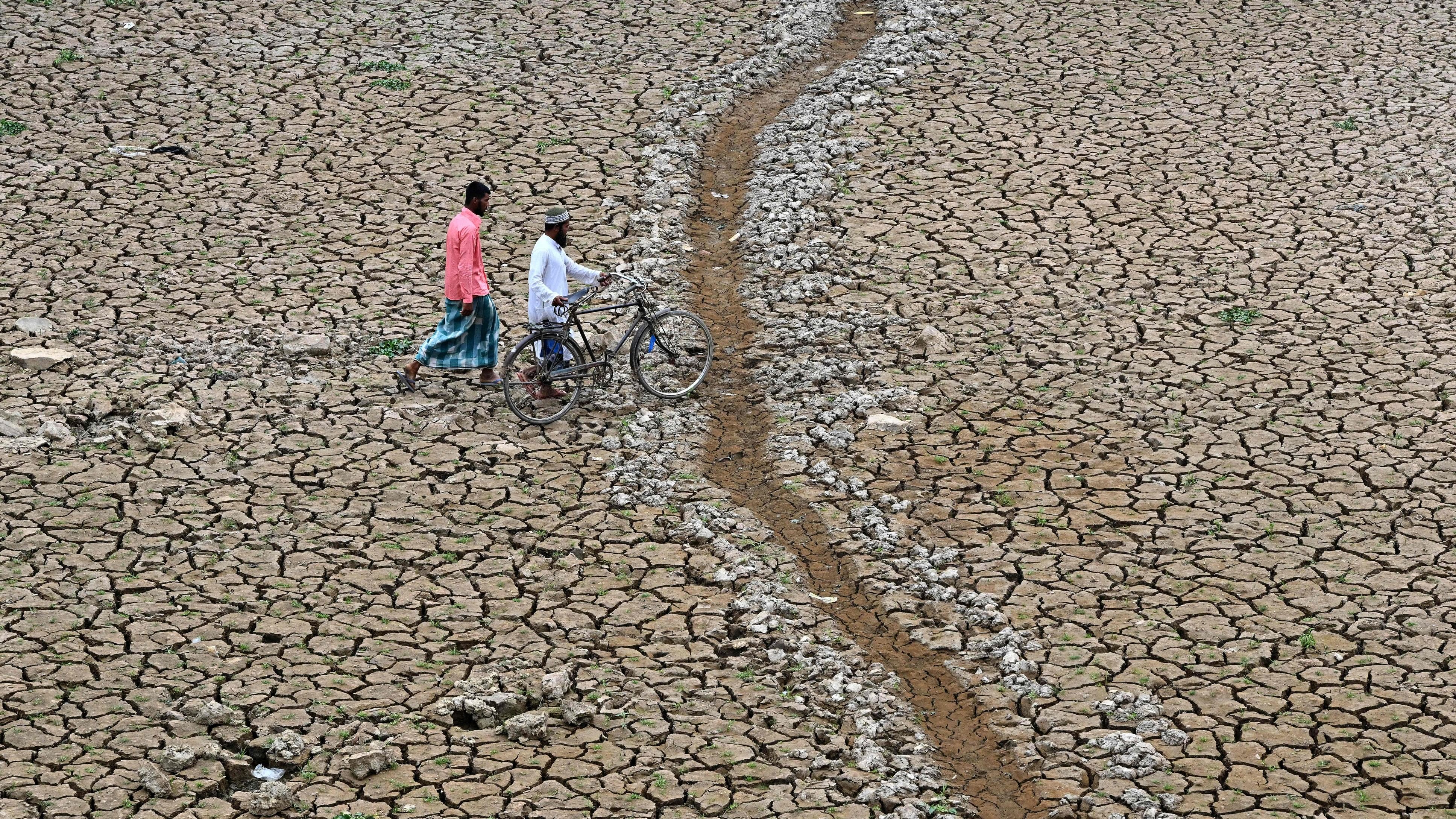 <div class="paragraphs"><p>Deaths caused due to heat increased by 55% in the last two decades in India. In pic, people walk across a dry lakebed in Nagaon district, Assam.&nbsp;</p></div>